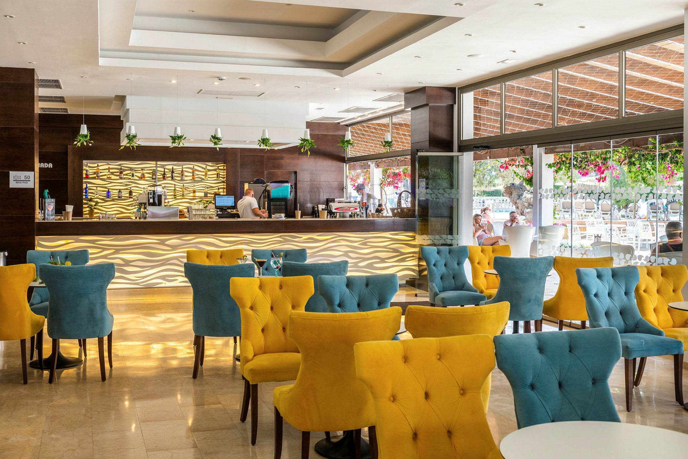 En modern hotellbar med färgglada stolar och dekorativa belysningsdetaljer. (AI-genererad text)