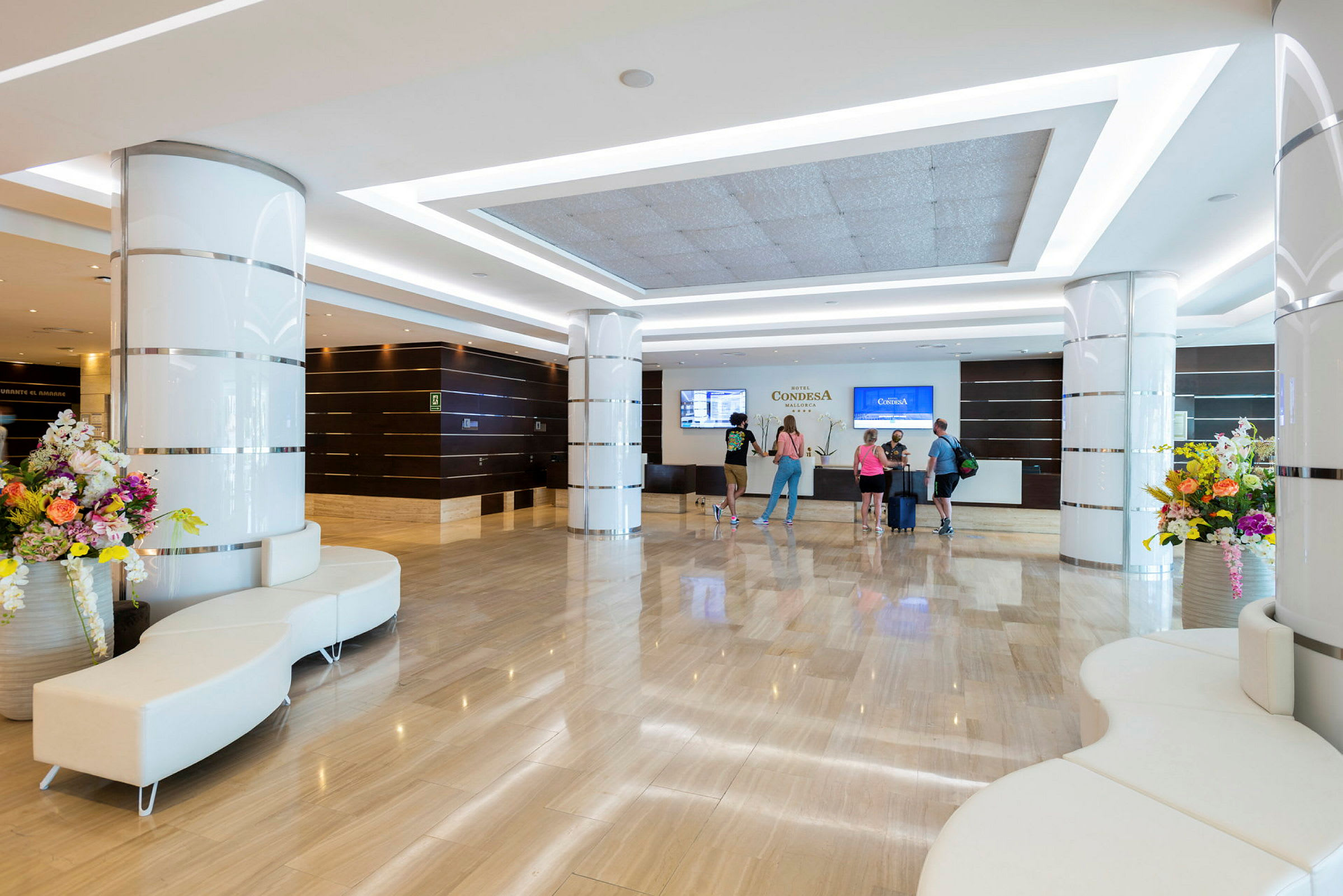 Hotellobby med reception, sittplatser och blommor. (AI-genererad text)