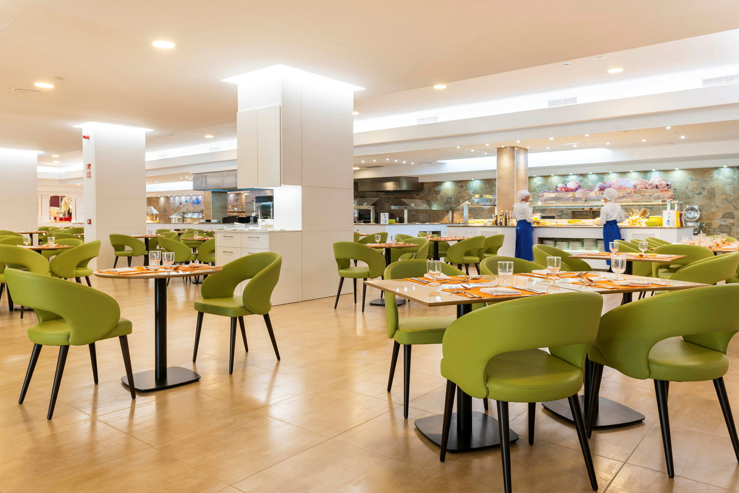 En restaurang med bord med gröna stolar och dukning. (AI-genererad text)