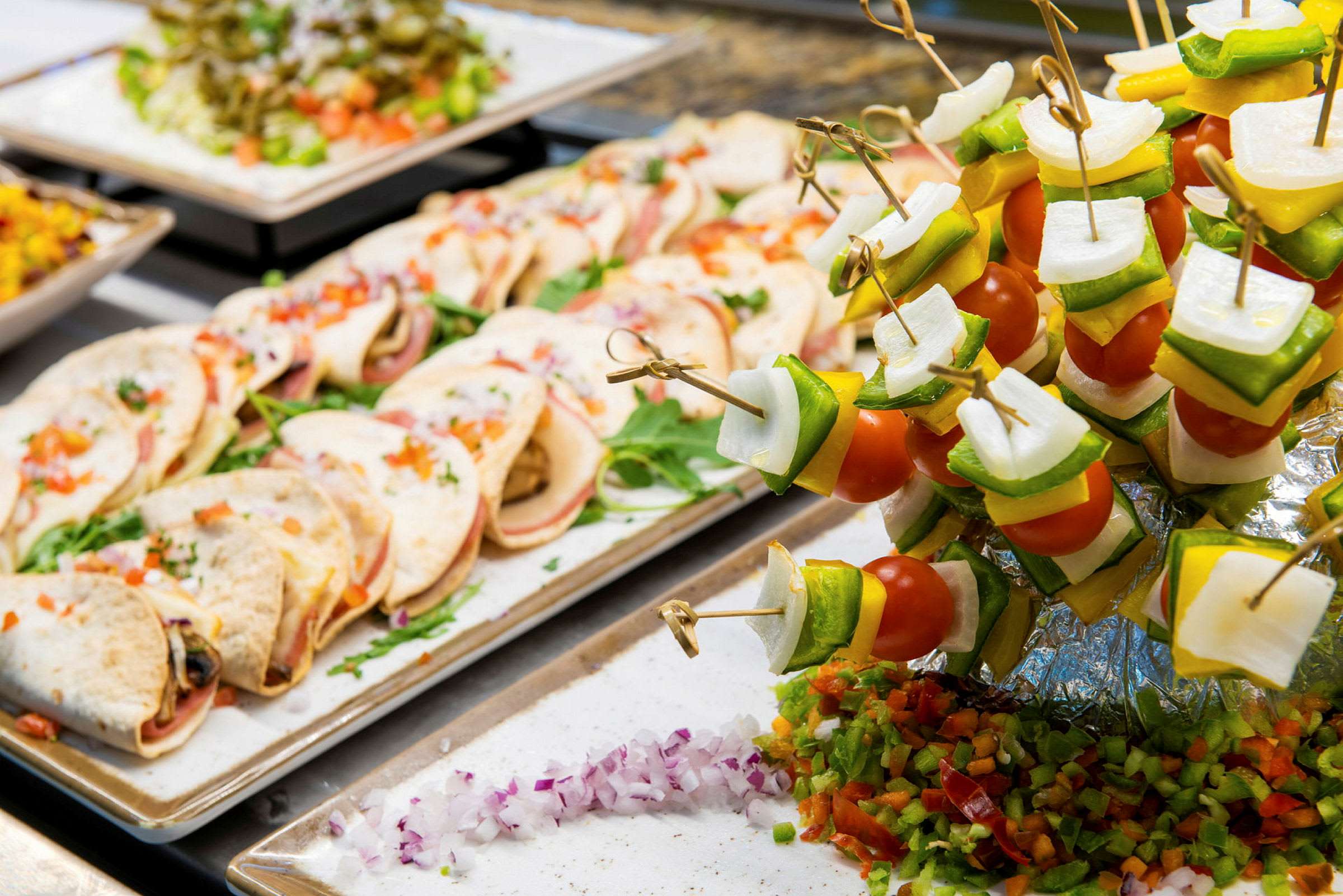 Buffé med små tortillas och färgglada grönsaksspett. (AI-genererad text)