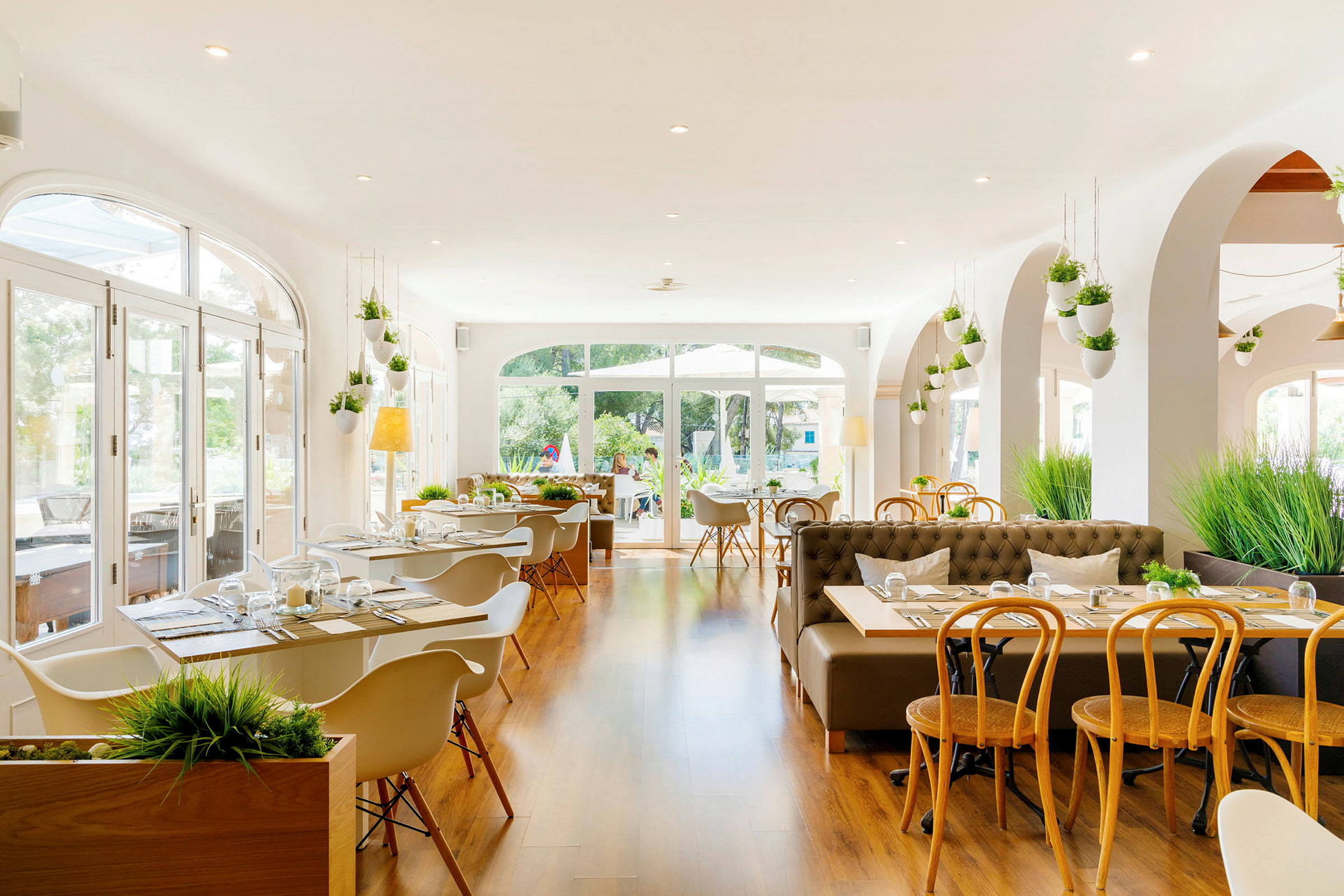 En ljus och modern restaurang med stora fönster och träinredning. (AI-genererad text)