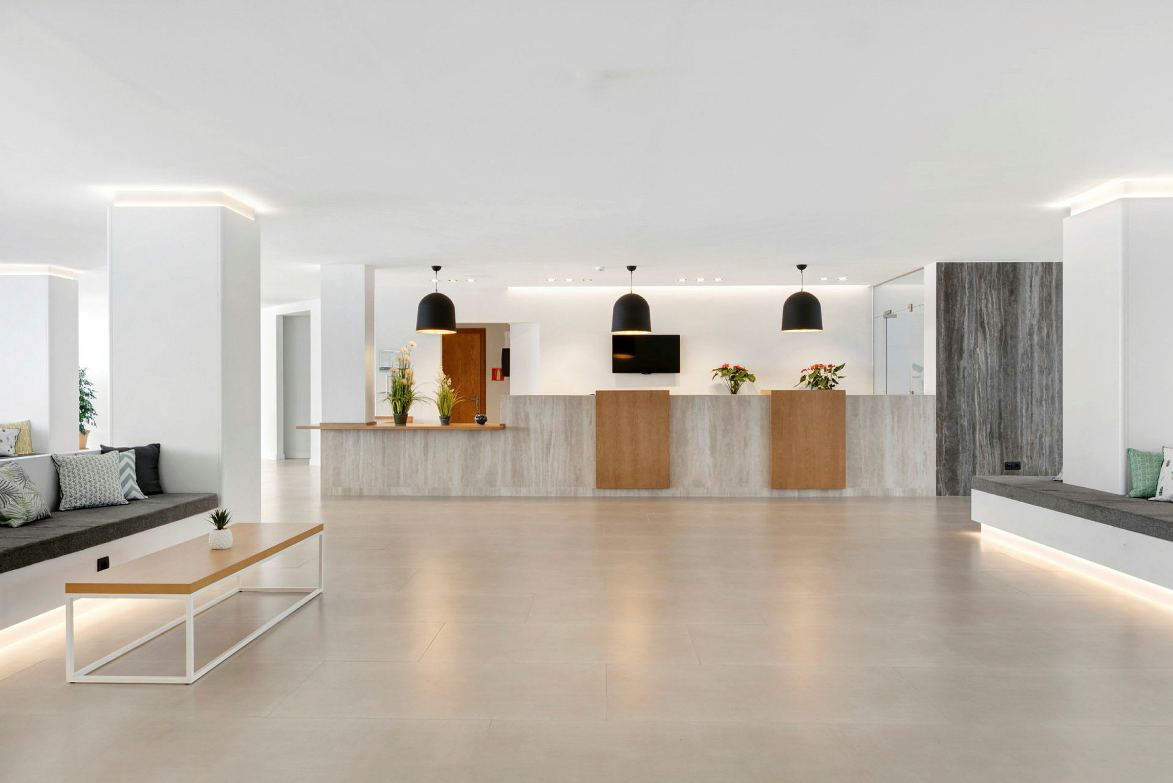 Hotellobby med receptionsdisk, moderna möbler och växter. (AI-genererad text)