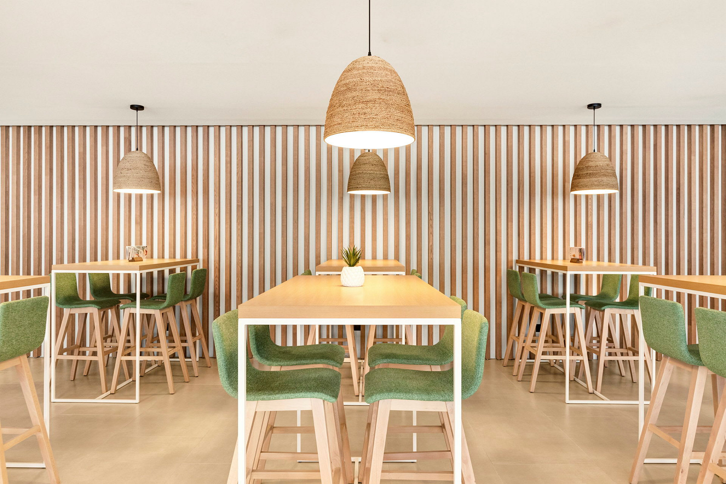 Bild på modern restauranginteriör med bord och stolar i trä och grönt, och hängande lampor. (AI-genererad text)