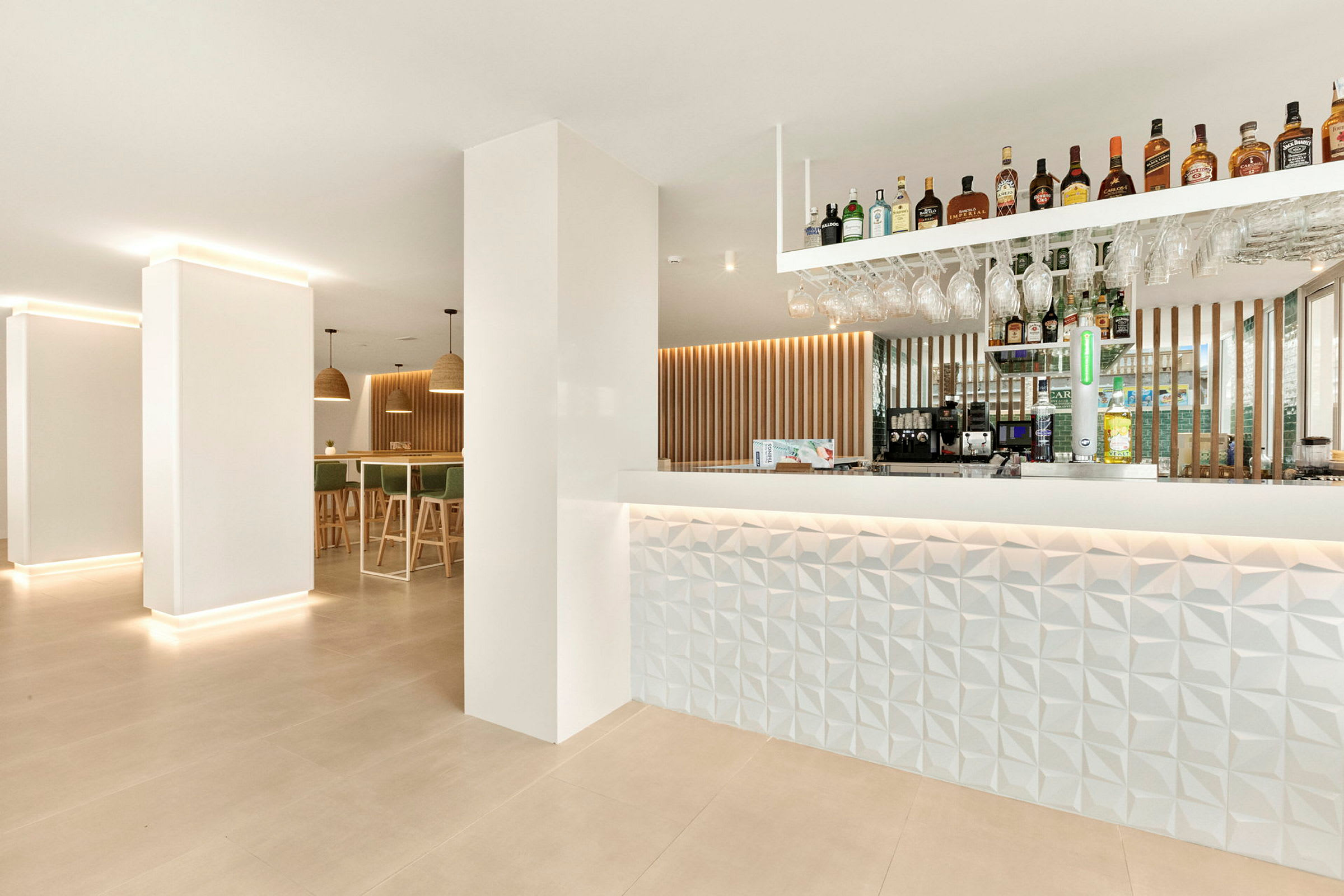 Modernt inredd hotellbar med upplyst disk och hyllor med drycker. (AI-genererad text)