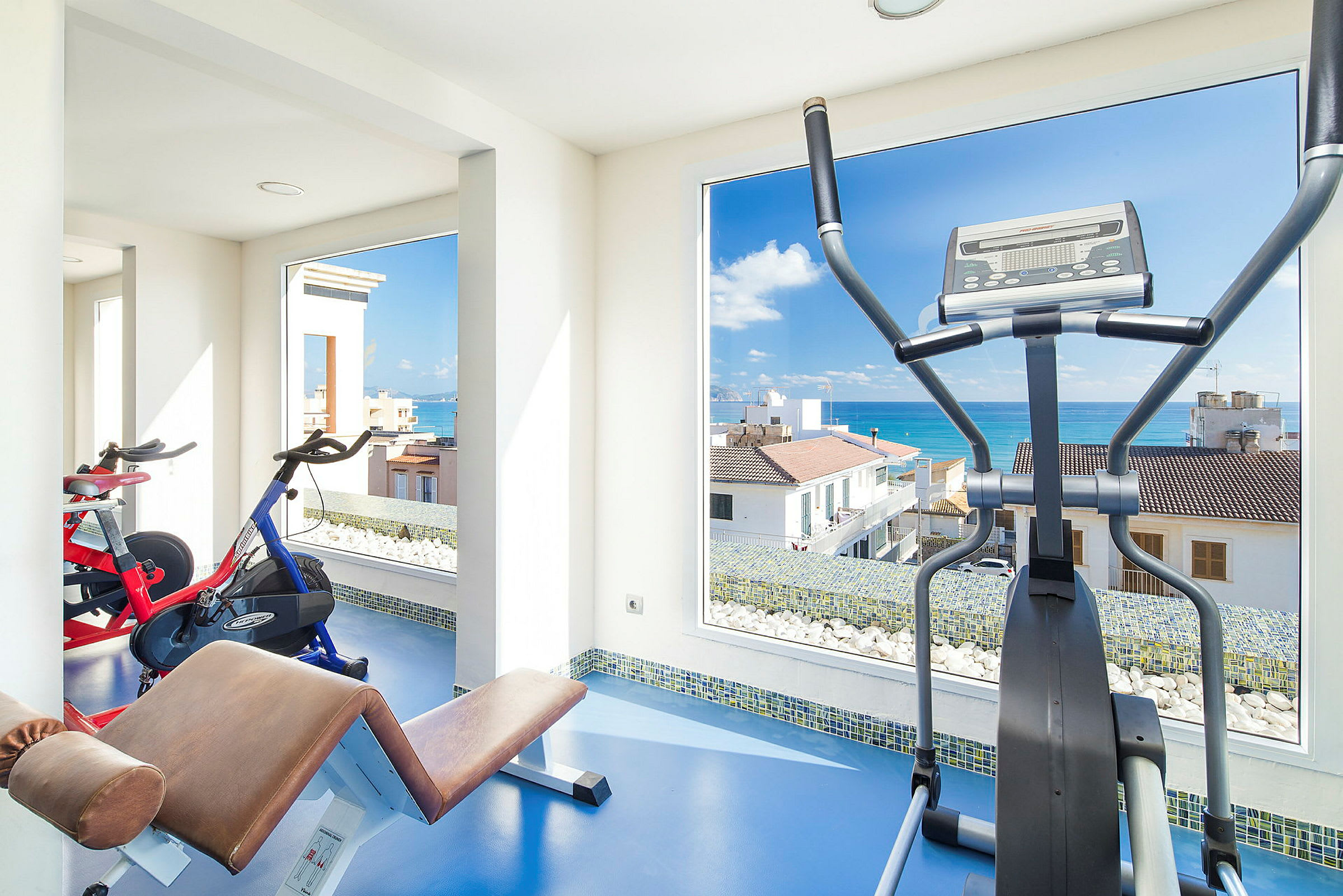Ett gym med träningsutrustning och utsikt över havet. (AI-genererad text)
