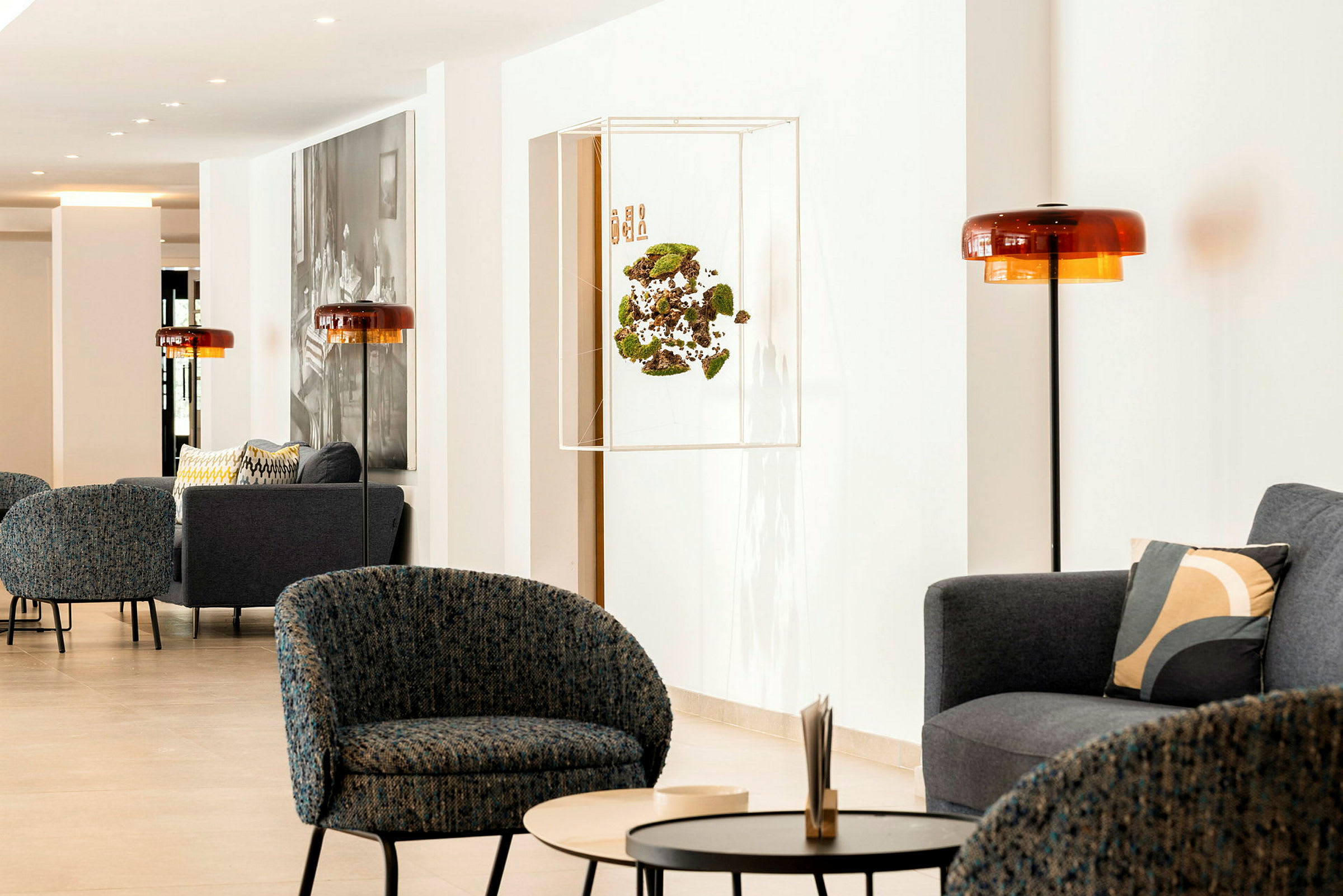 En modern loungemiljö med fåtöljer, soffor och bord i en ljus inomhusmiljö. (AI-genererad text)
