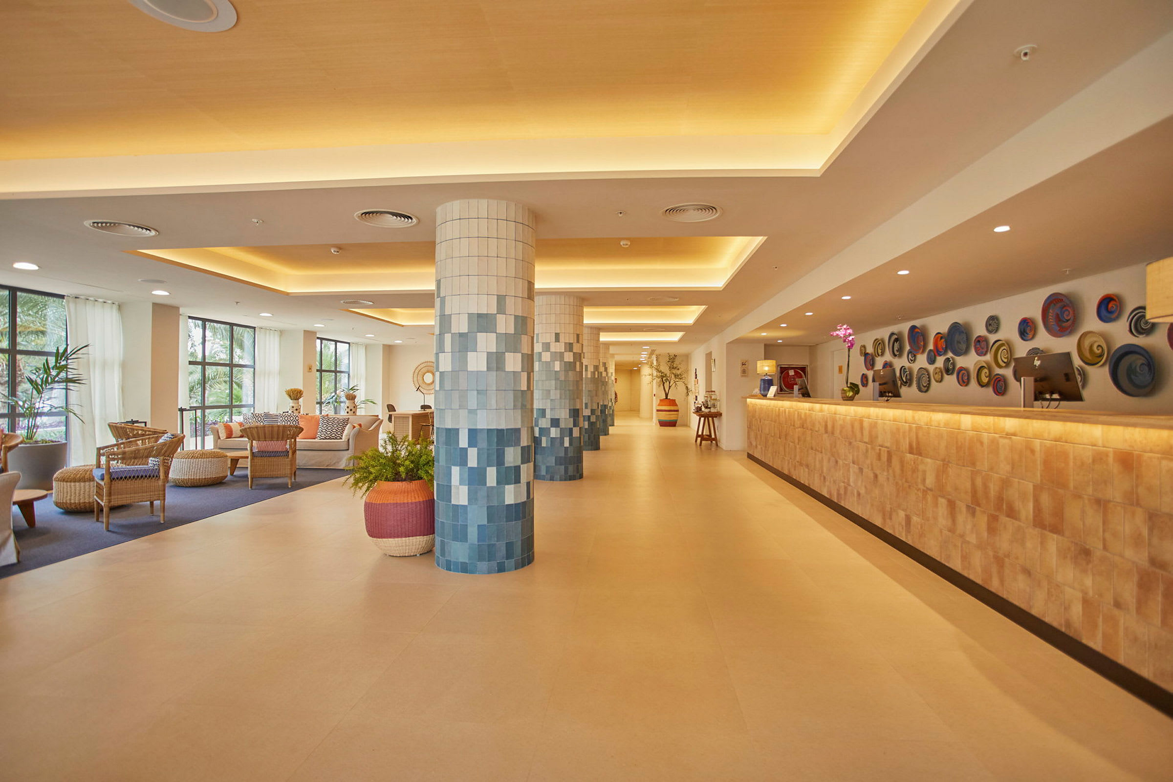 Hotellobby med sittgrupper, dekorerade pelare och reception. (AI-genererad text)
