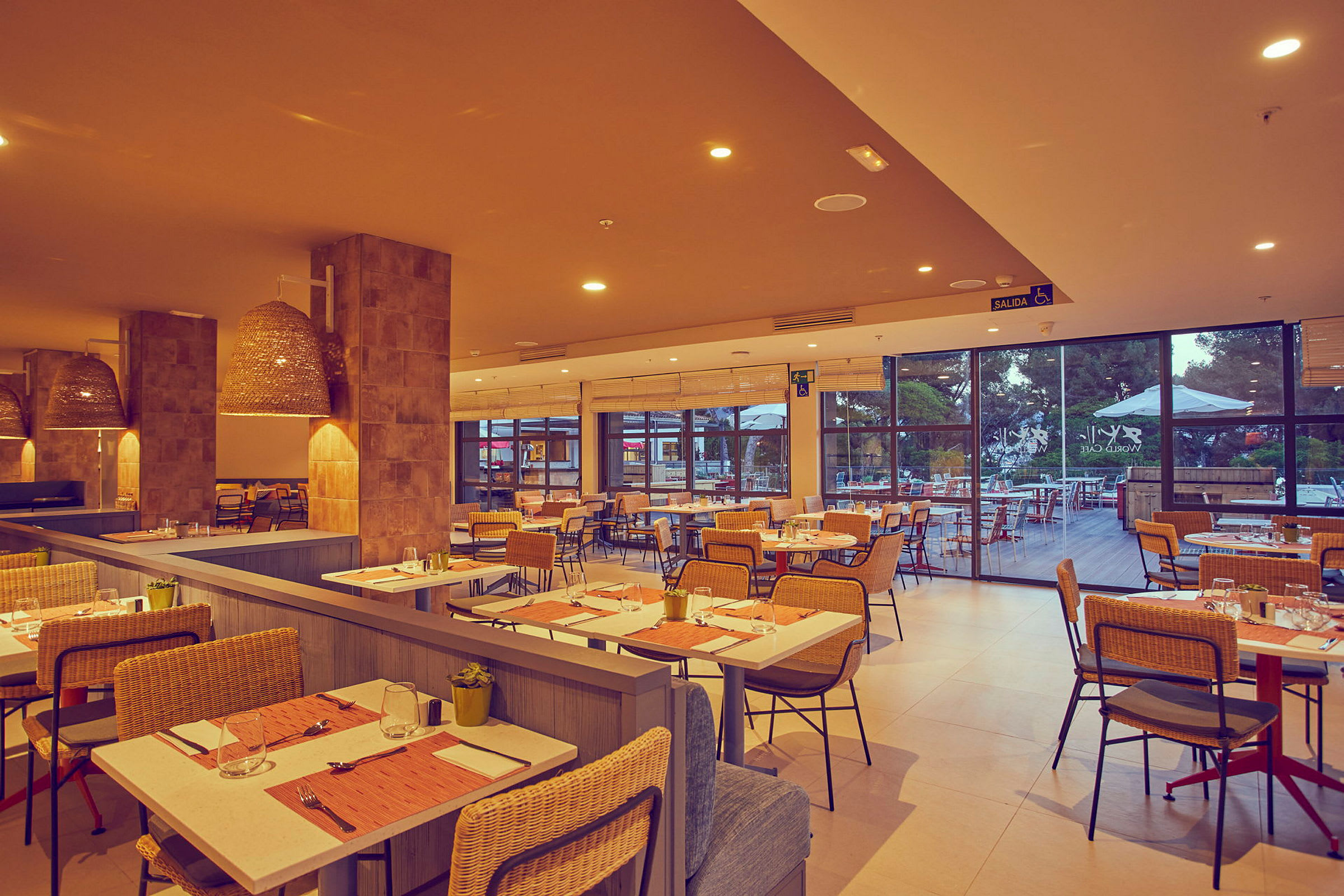 Interiör av en restaurang med dukade bord och rottingstolar. (AI-genererad text)