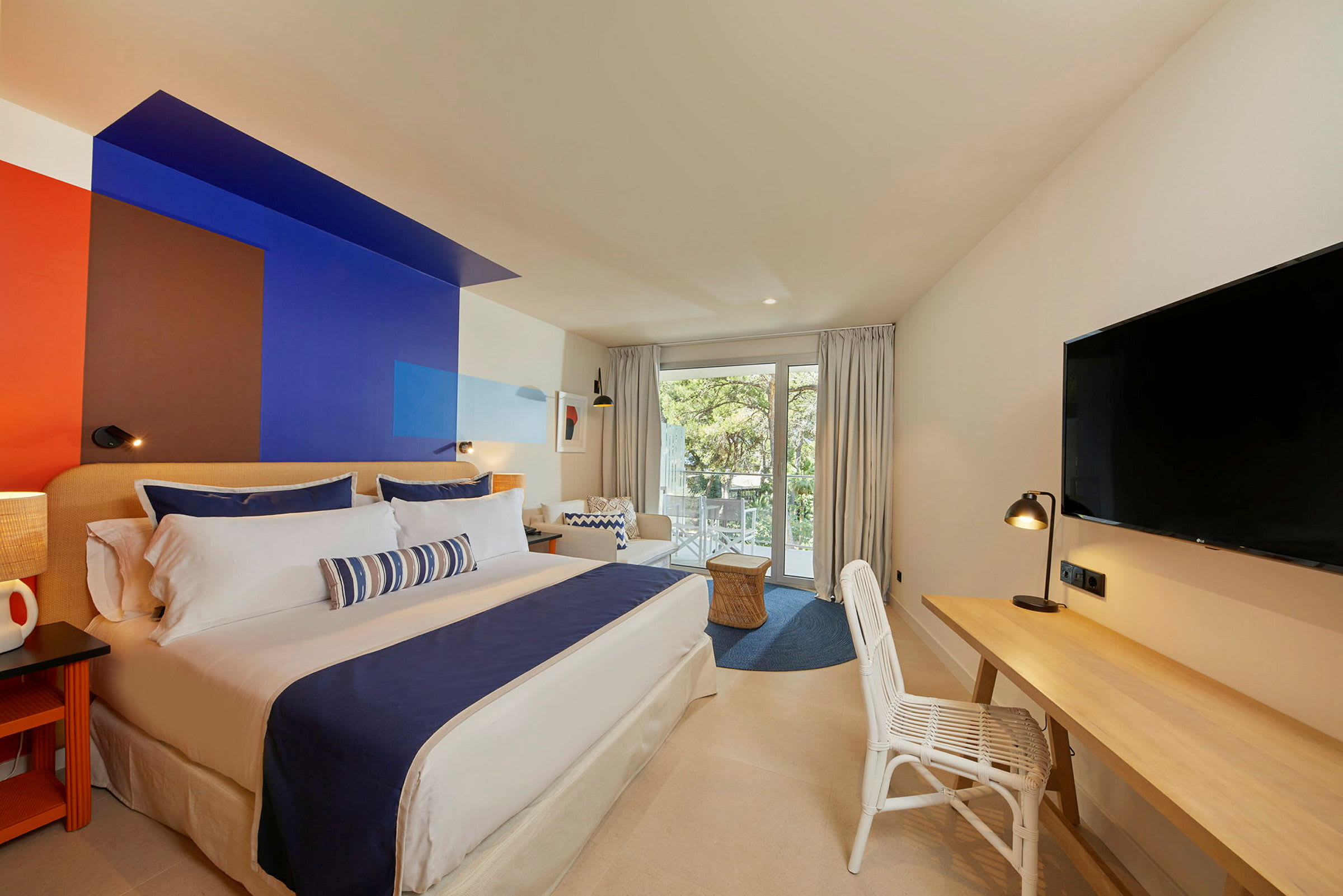Modern hotellrum med en stor dubbelsäng och en färgglad väggdesign. (AI-genererad text)
