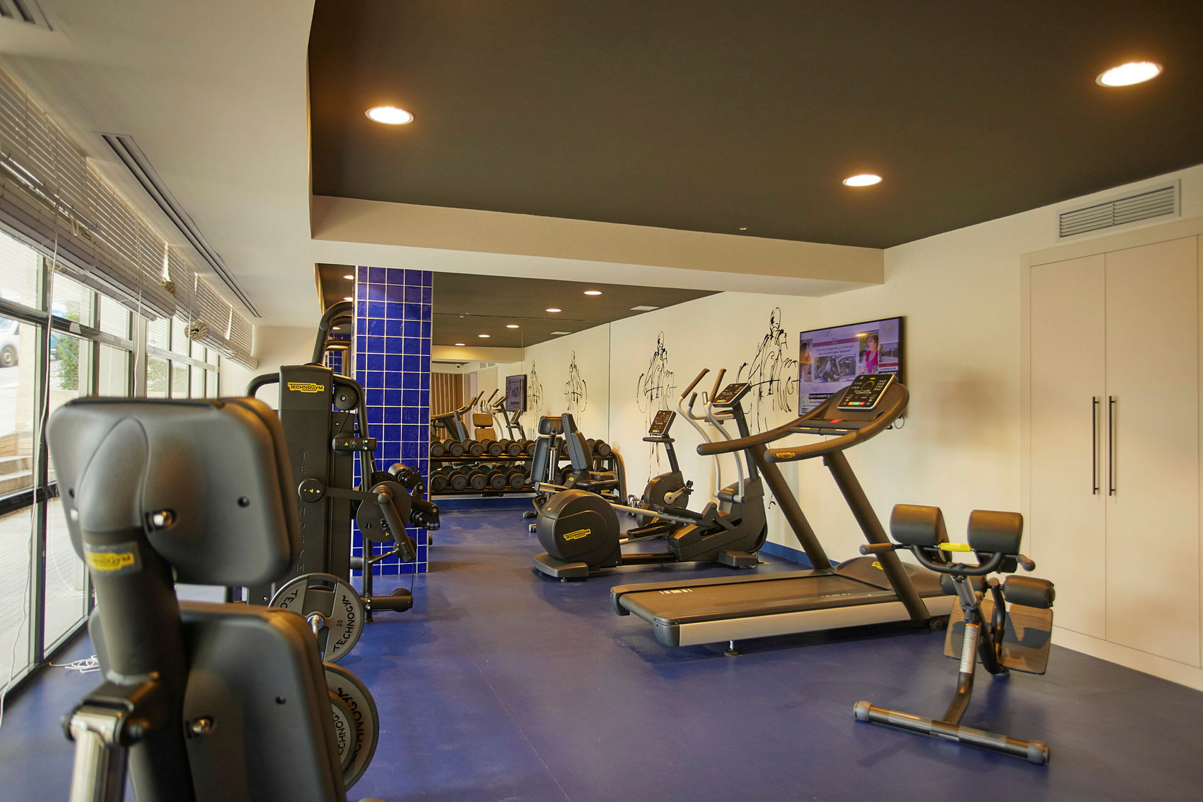 Bild av ett gym med träningsmaskiner och vikter. (AI-genererad text)