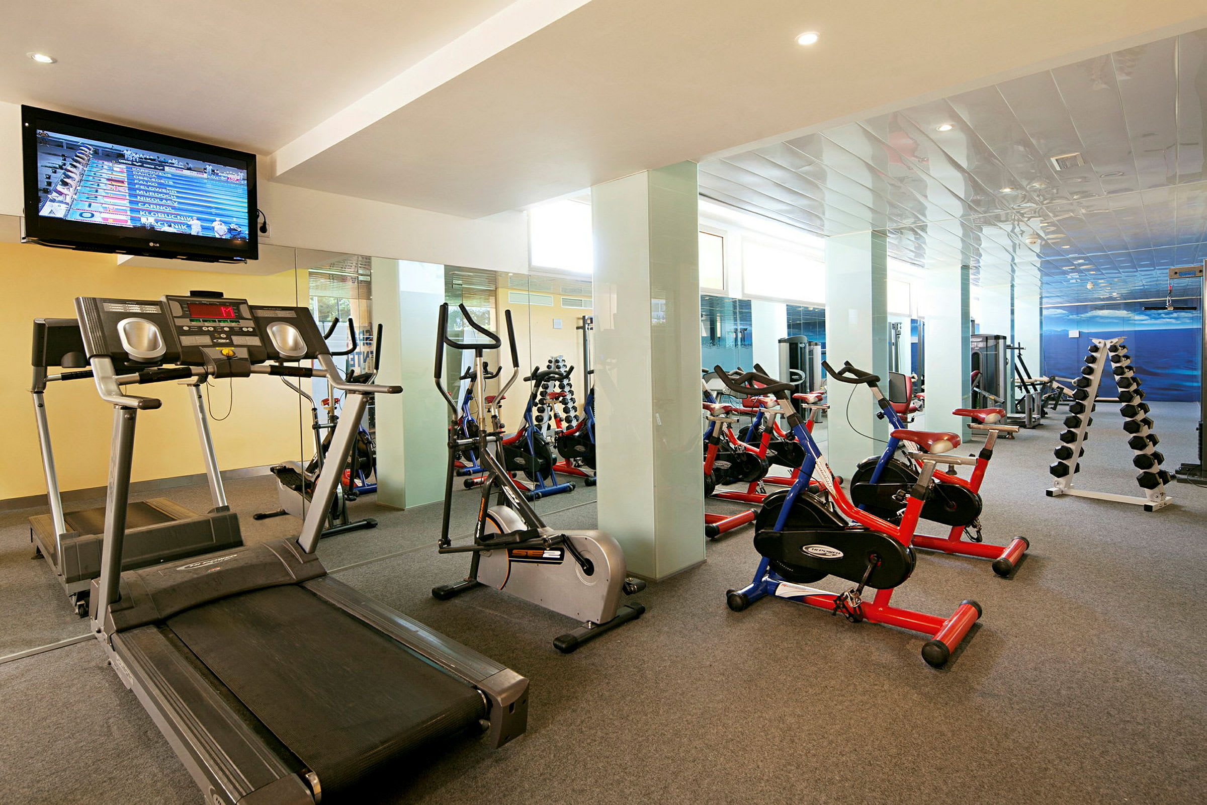Ett gym med löpband, träningscyklar och hantlar. (AI-genererad text)
