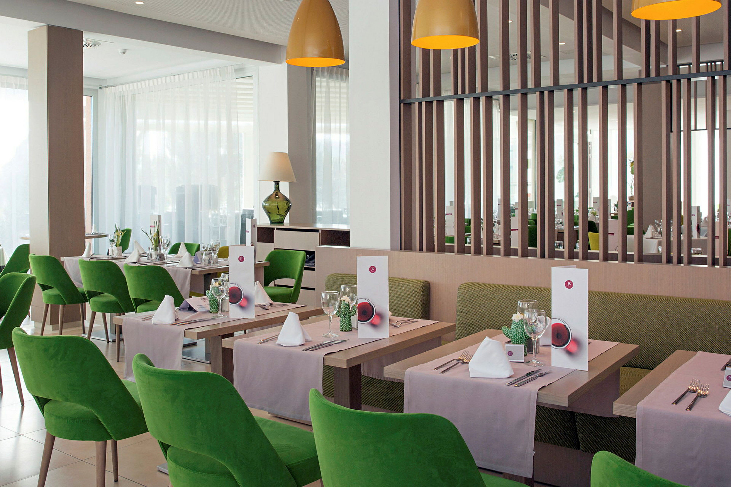 Restaurang med gröna stolar och dukade bord. (AI-genererad text)
