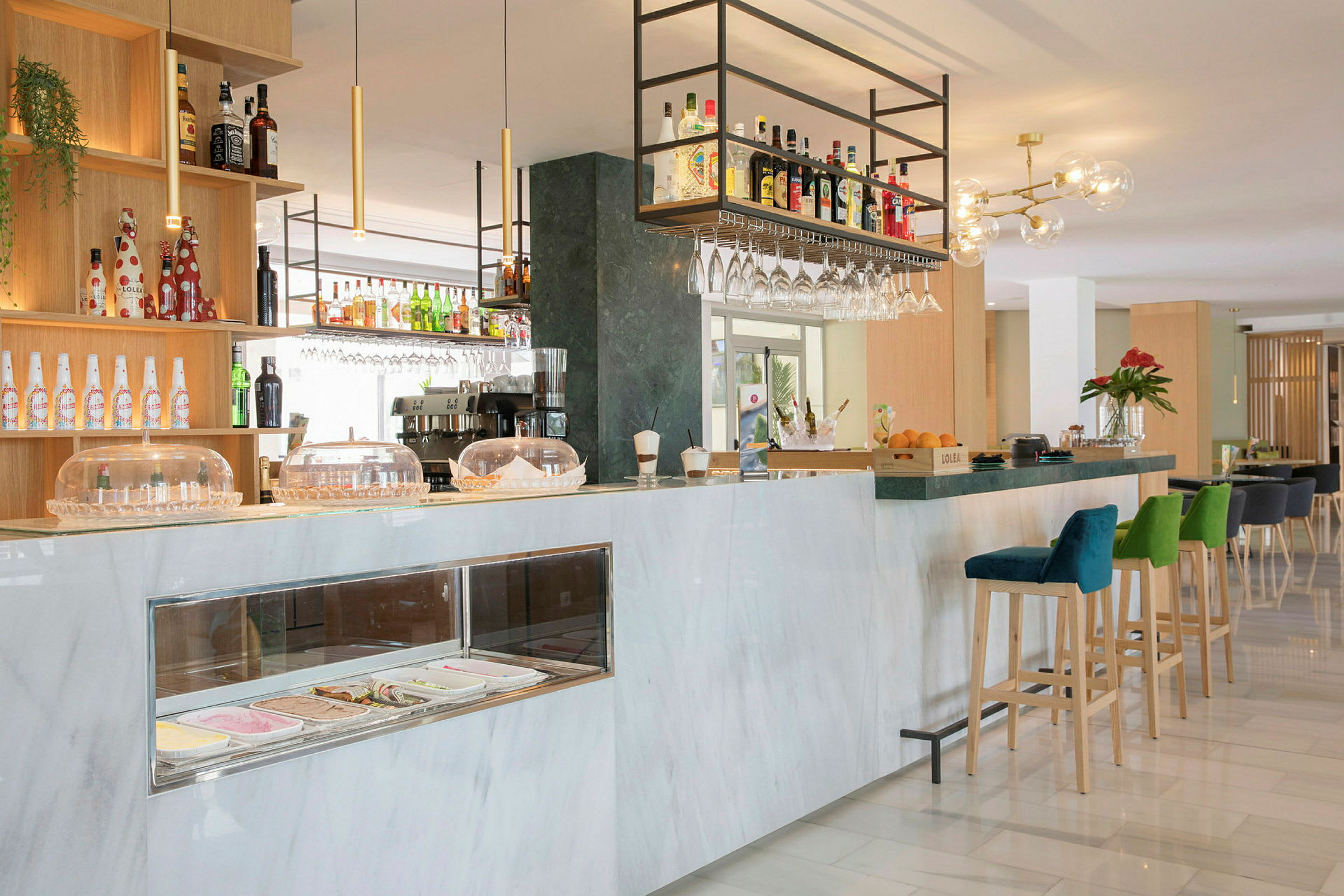 En modern hotellbar med marmordisk, barstolar och hyllor fyllda med flaskor. (AI-genererad text)