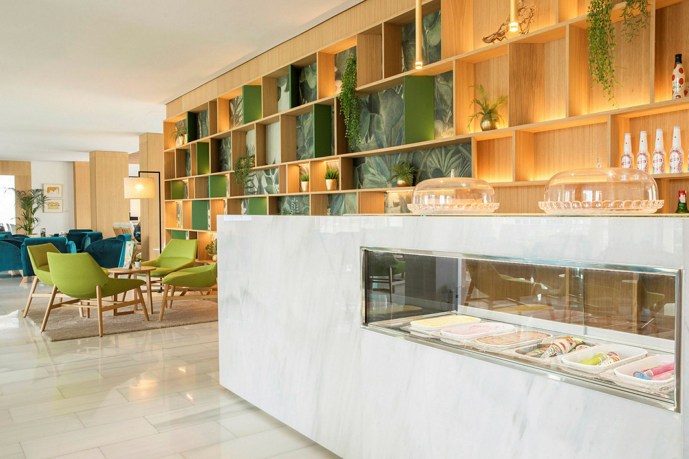 En modern lounge med gröna och blå sittmöbler och en marmordisk. (AI-genererad text)