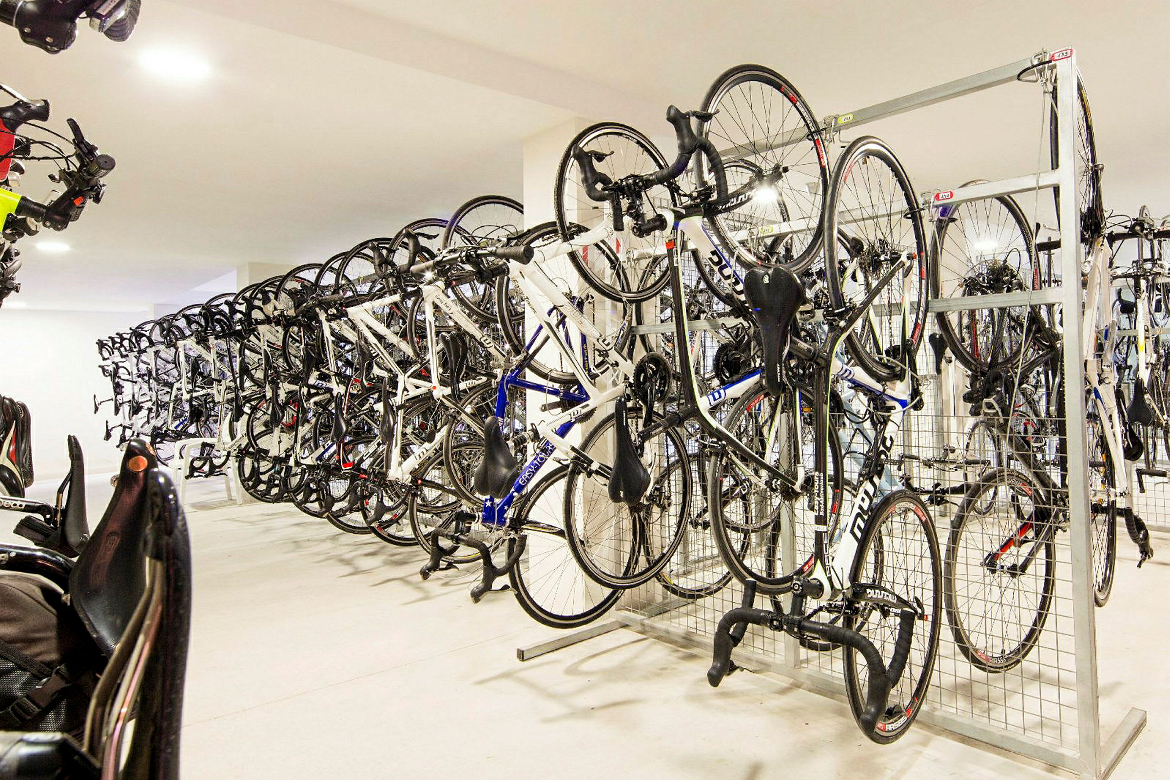 En cykelförvaring med flera cyklar hängande på ställ. (AI-genererad text)
