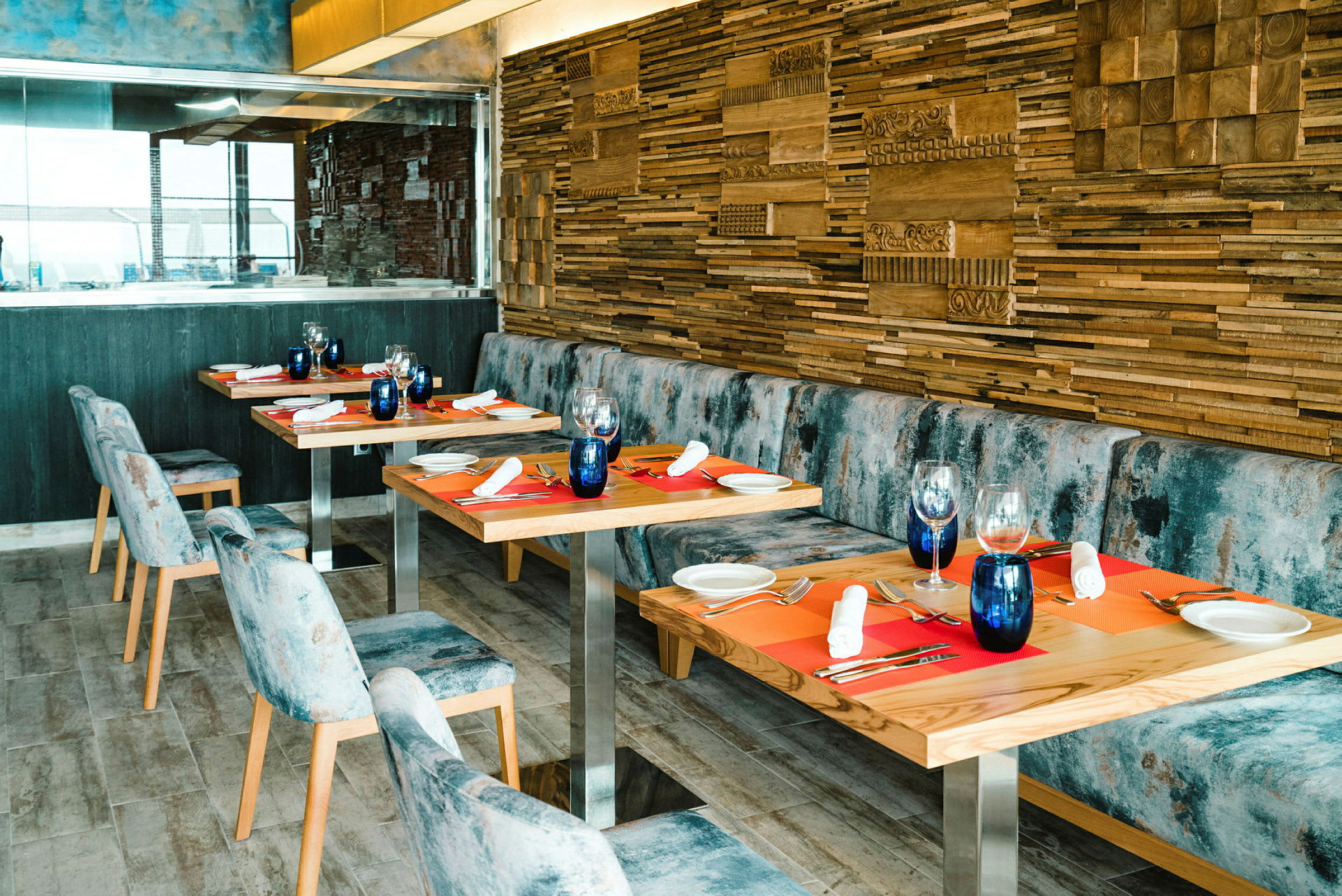 En restaurang med träbord, blå stolar och dekorerade träväggar. (AI-genererad text)