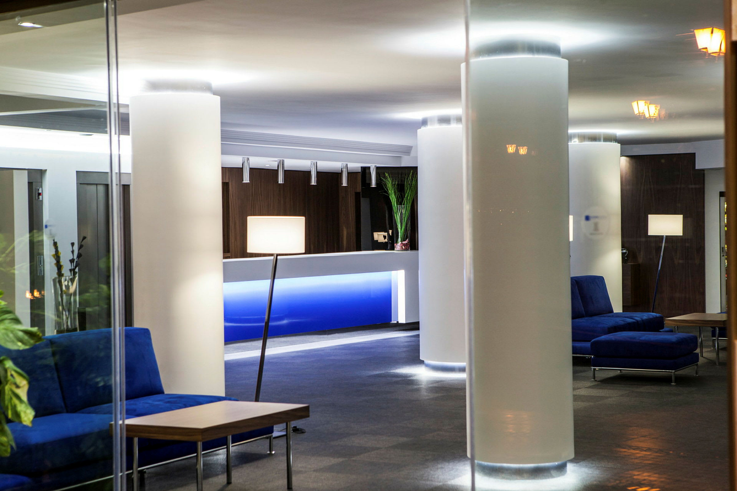 Ett hotellobby med soffor, bord och en reception. (AI-genererad text)