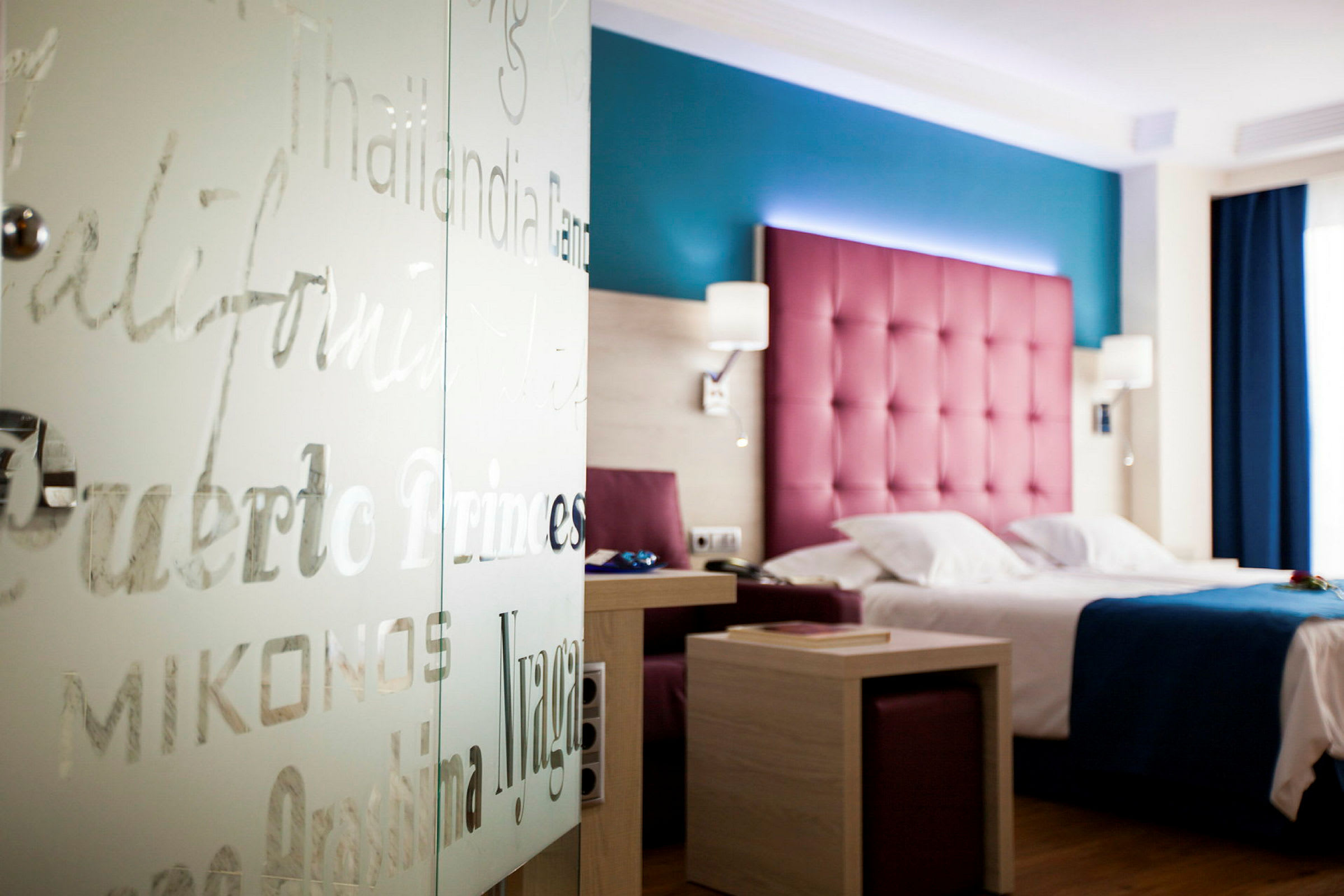 Hotellrum med färgglad inredning, säng och bord. (AI-genererad text)