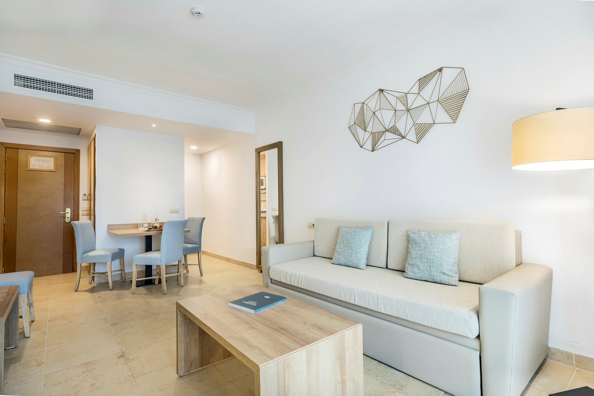 Ett modernt vardagsrum med beige soffa, trämöbler och en geometrisk väggdekoration. (AI-genererad text)