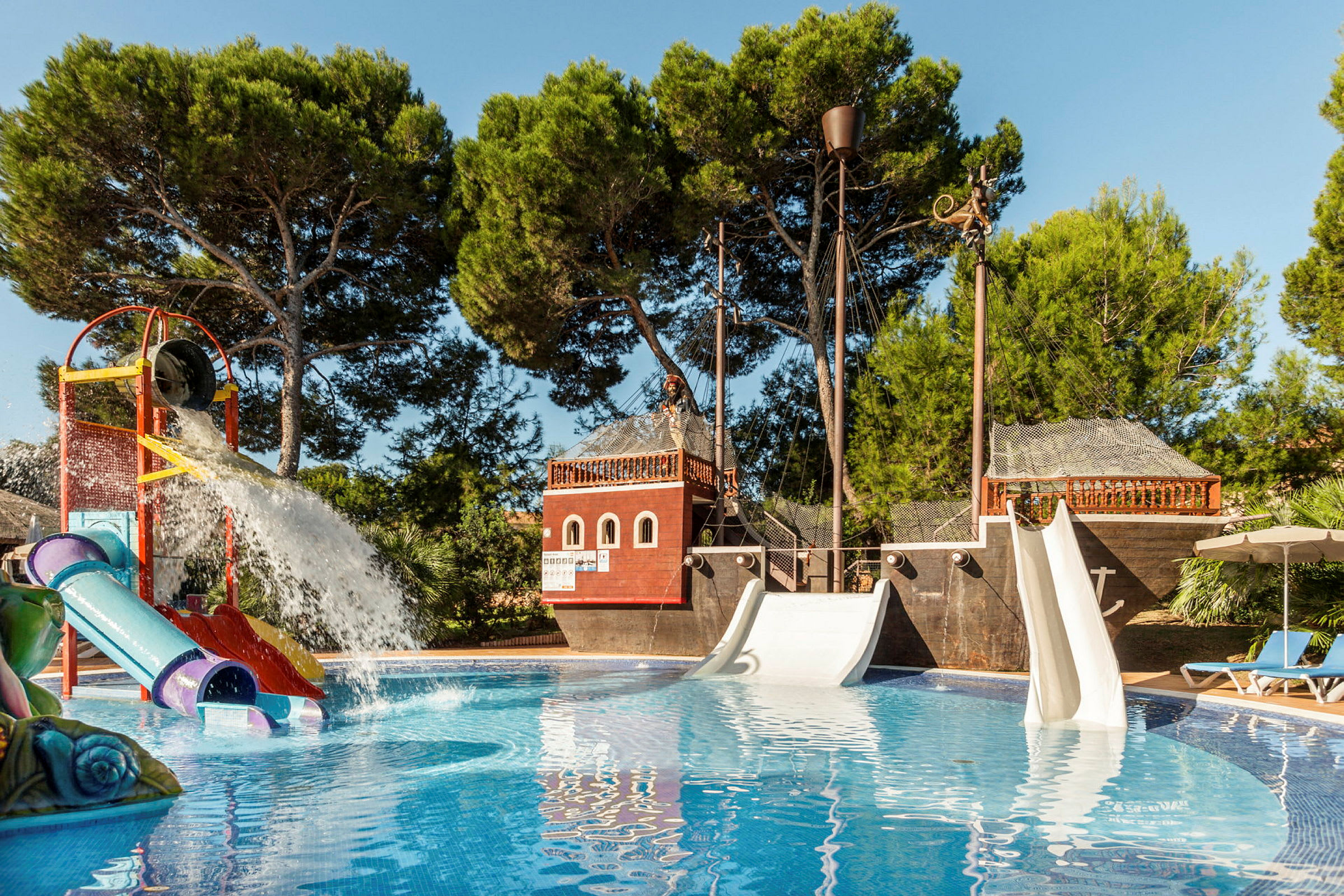 En pool med rutschkanor och ett piratskepp som lekplats. (AI-genererad text)