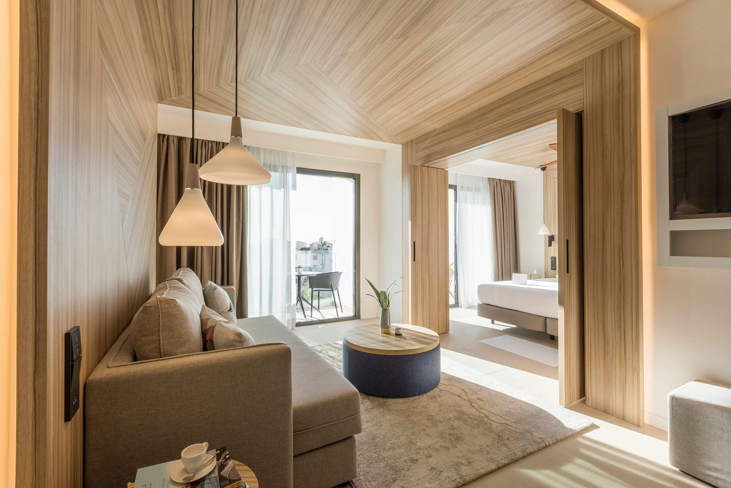 Ett modernt hotellrum med separat sovrum och sittplats. Rummet har stora fönster och stilren inredning. (AI-genererad text)
