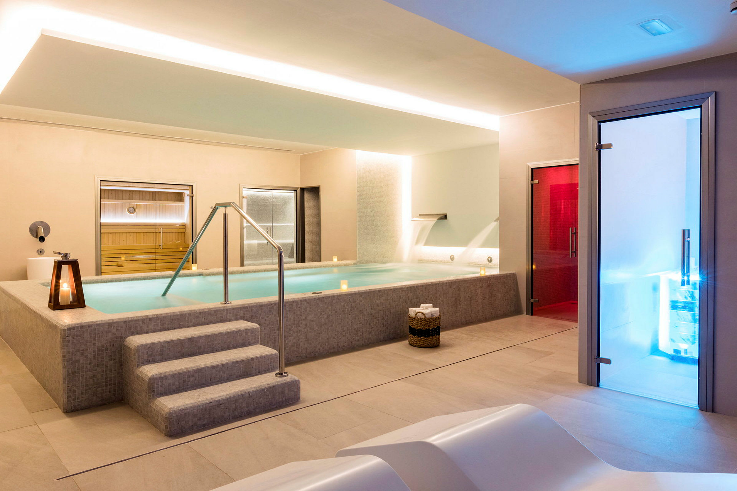 Bild av ett modernt spa med en pool, bastu och färgade rumsbelysningar. (AI-genererad text)