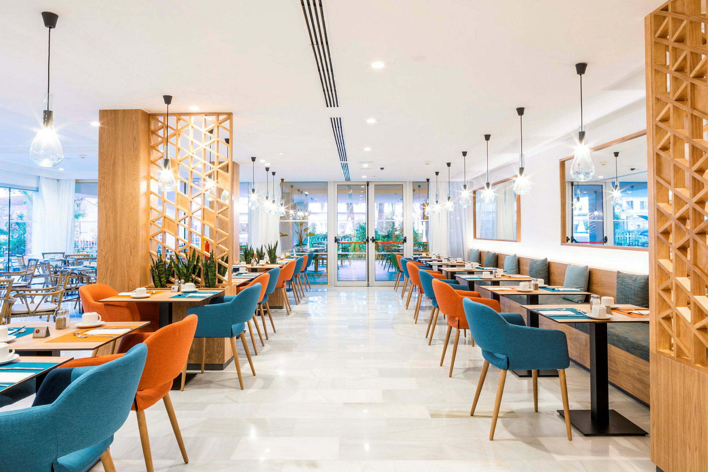 En modern restaurang med färgglada stolar och eleganta belysningar. (AI-genererad text)