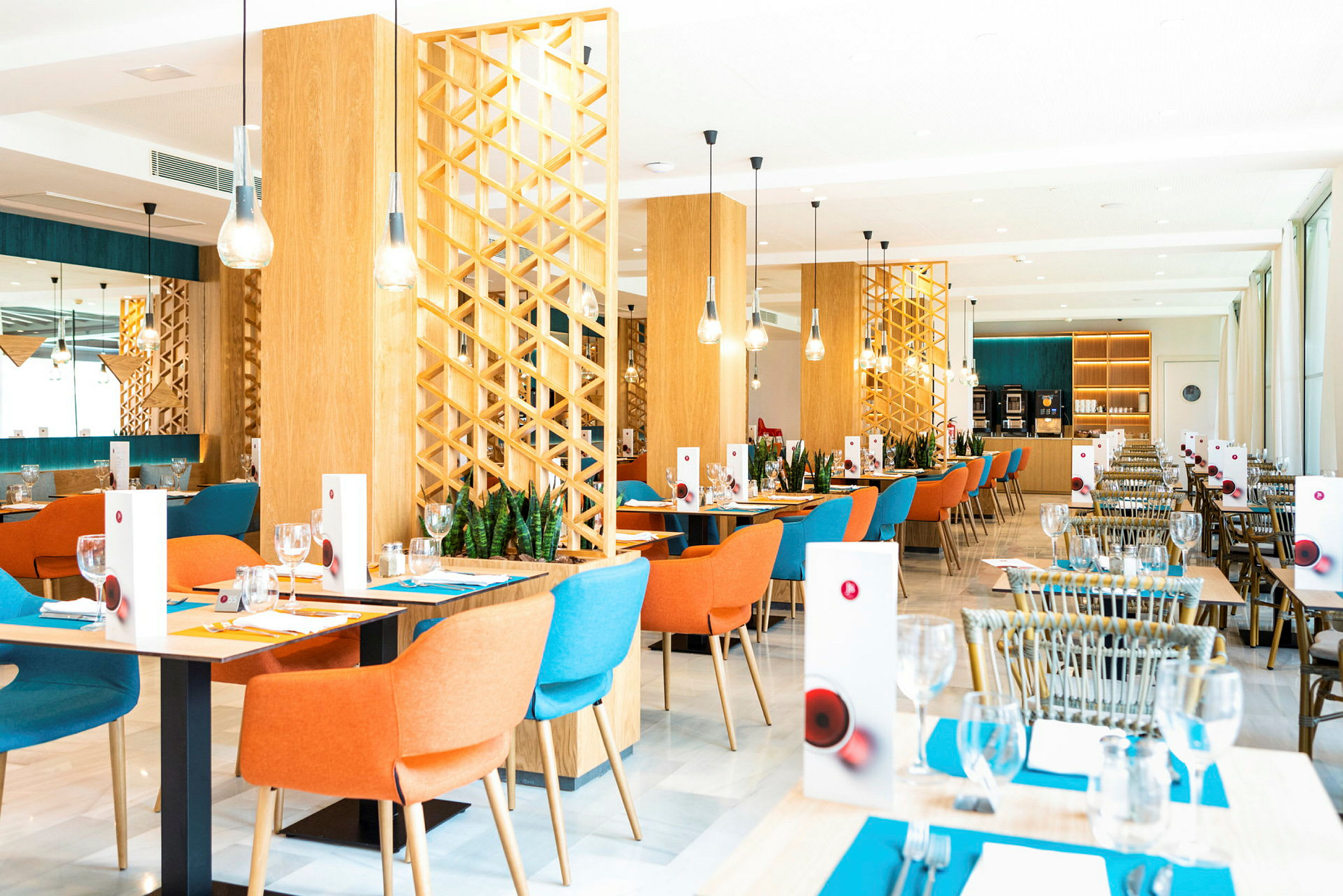 Bild av en restaurang med färgglada stolar och bord dukade med menyer och glas. (AI-genererad text)