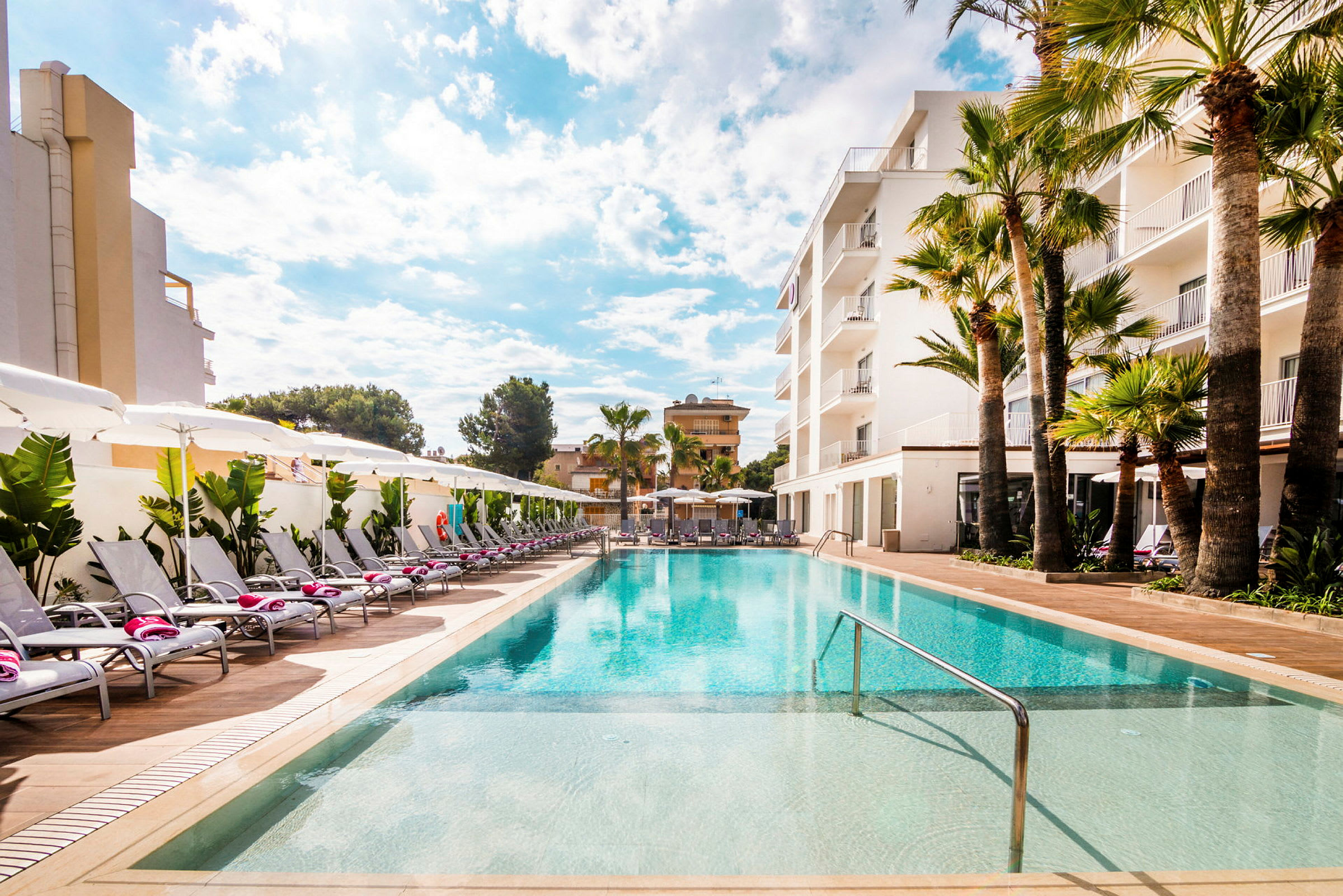 Swimmingpool vid hotell med solstolar och parasoller. (AI-genererad text)