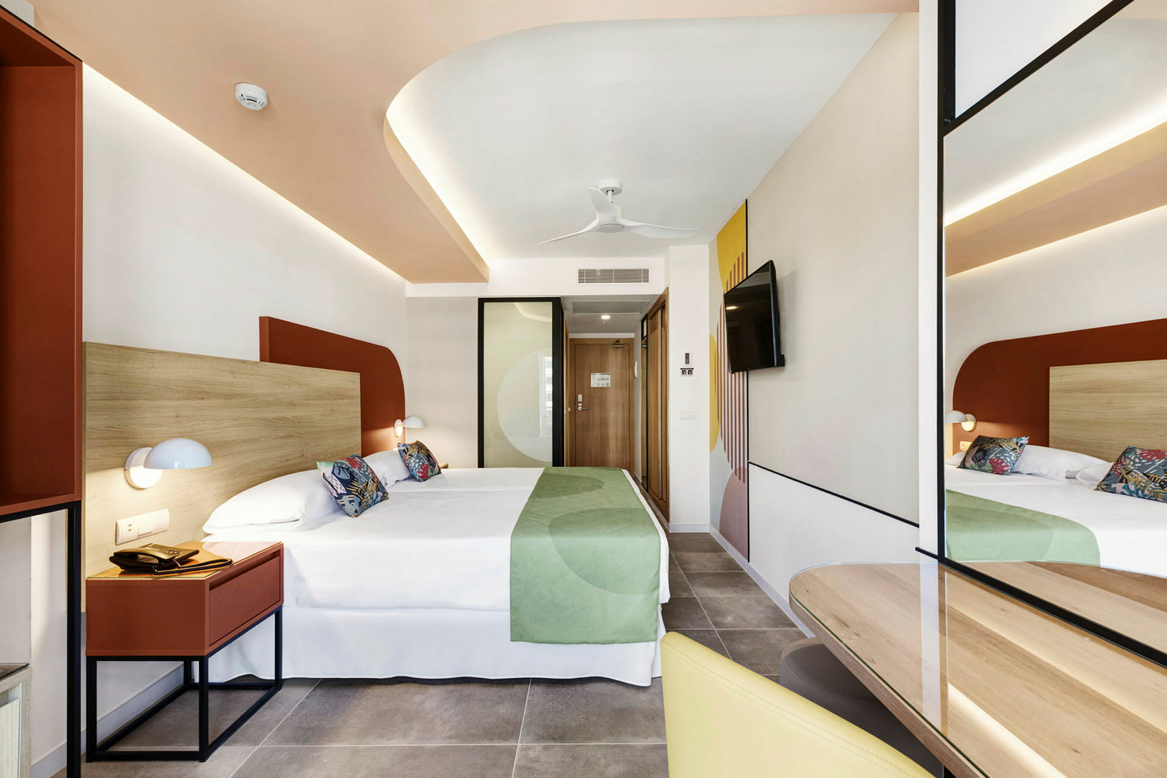 Hotellrum med modern inredning, dubbelsäng och spegel. (AI-genererad text)