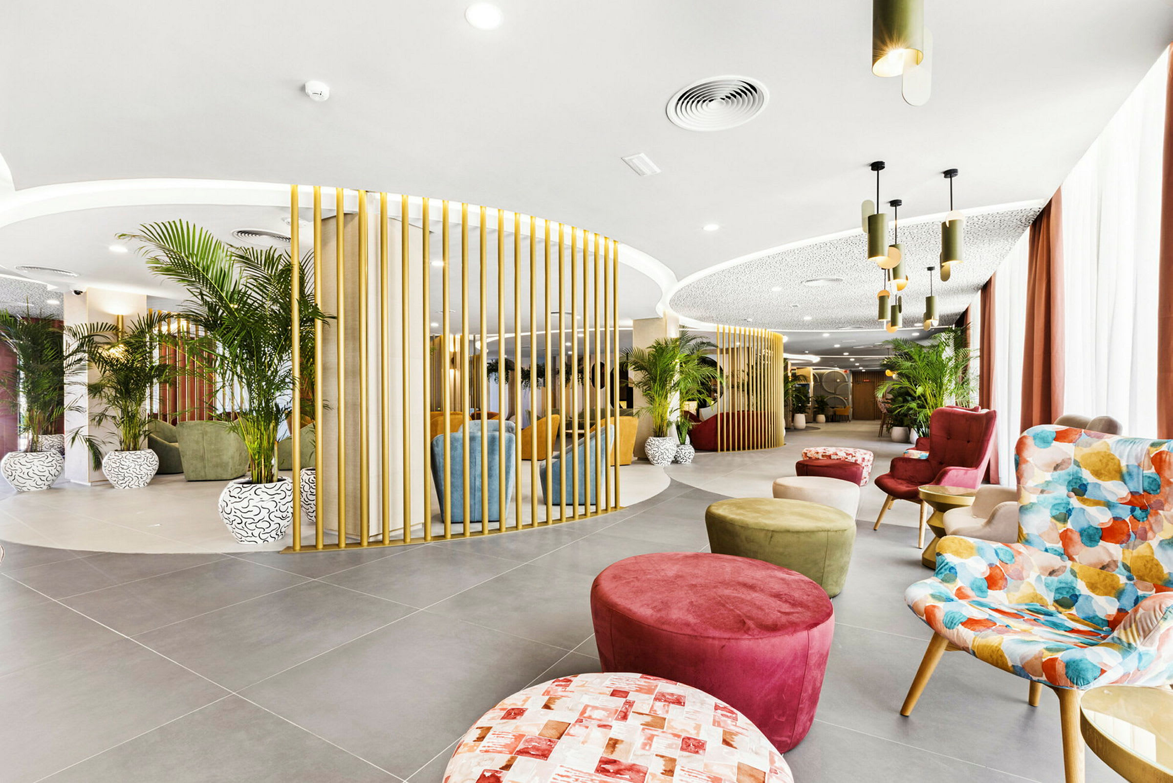 En modern lounge med färgglada sittmöbler, växtdekorationer och elegant belysning. (AI-genererad text)
