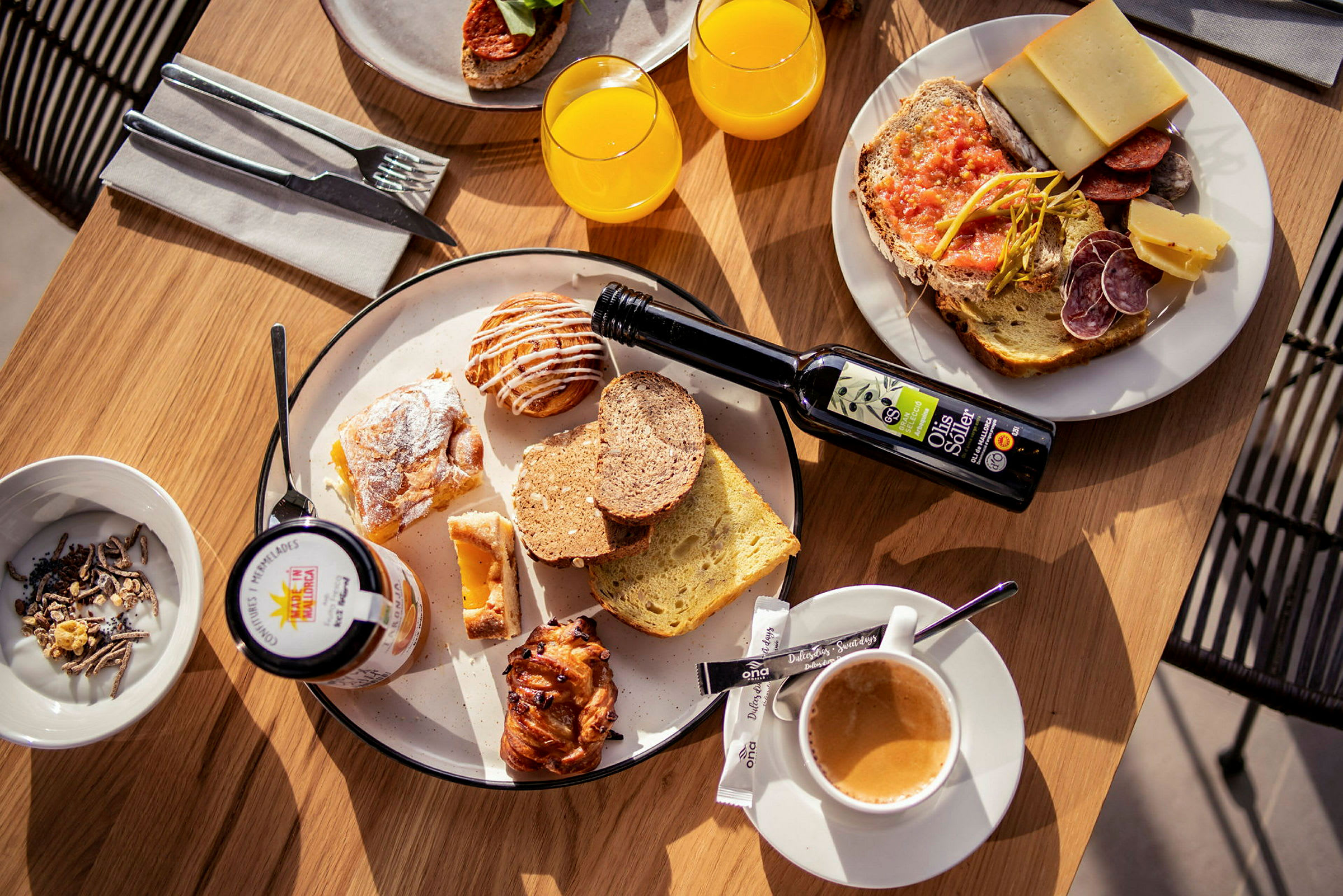 Ett bord dukat med en frukost som inkluderar bröd, bakverk, juice, kaffe och pålägg. (AI-genererad text)