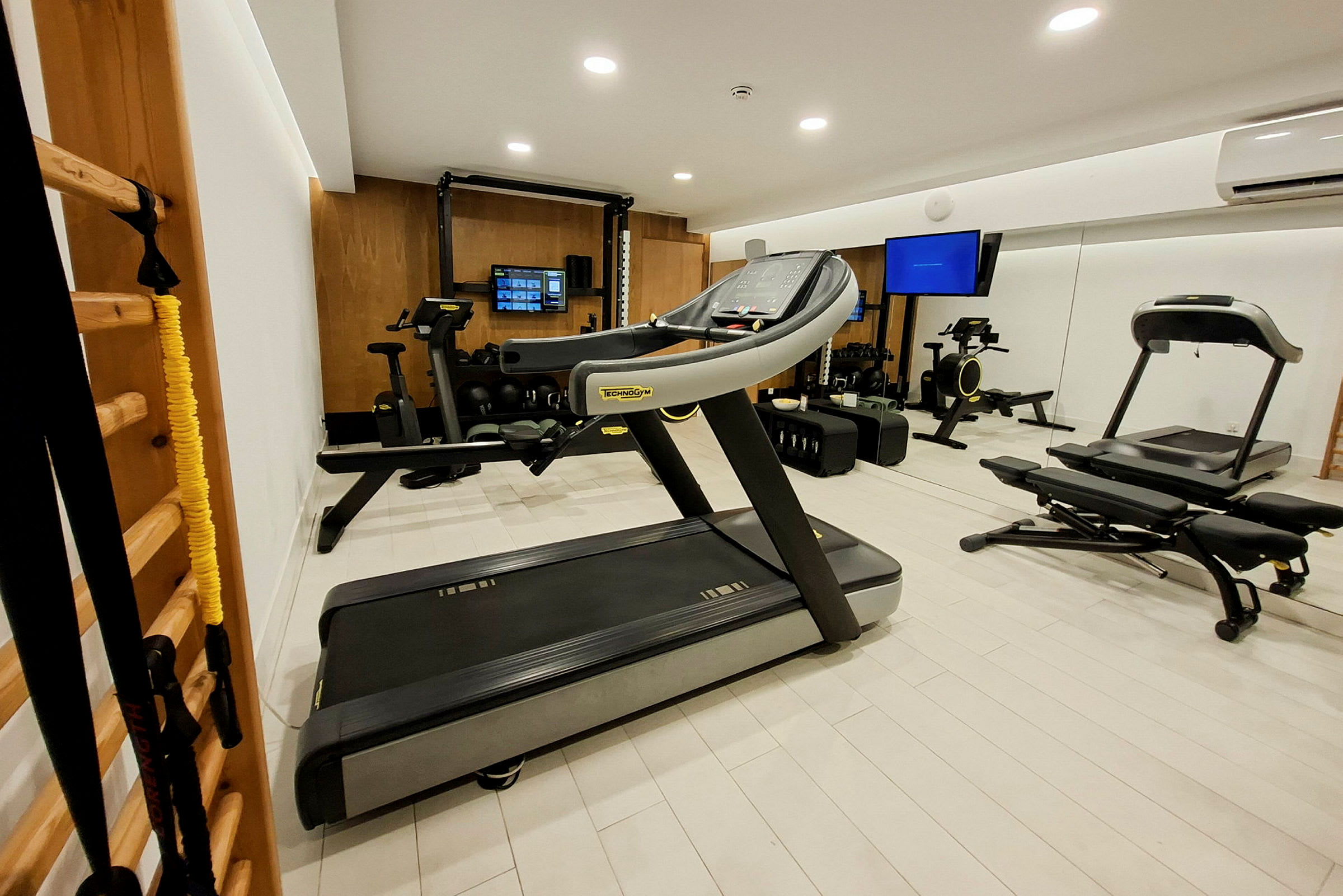 Ett modernt gym med träningsmaskiner, löpband och spegelvägg. (AI-genererad text)