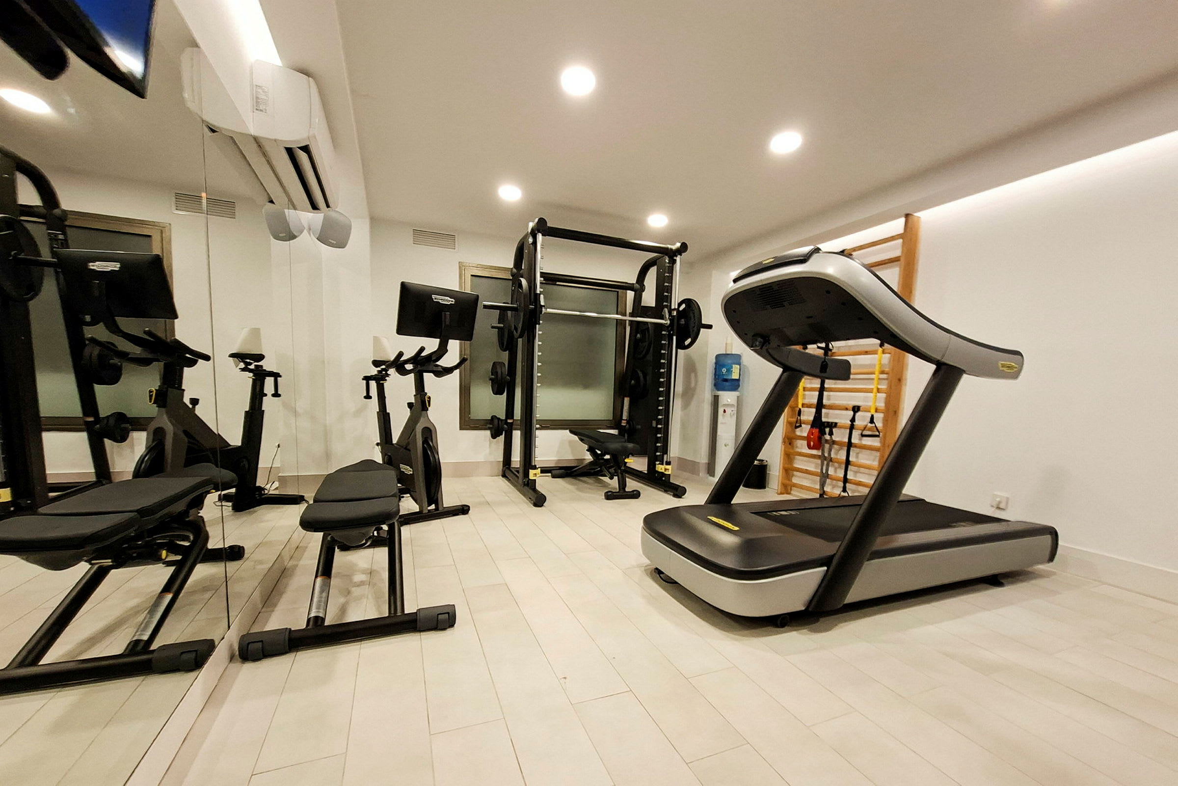 Ett gym med träningsmaskiner inklusive ett löpband, motionscyklar och styrketräningsutrustning. (AI-genererad text)