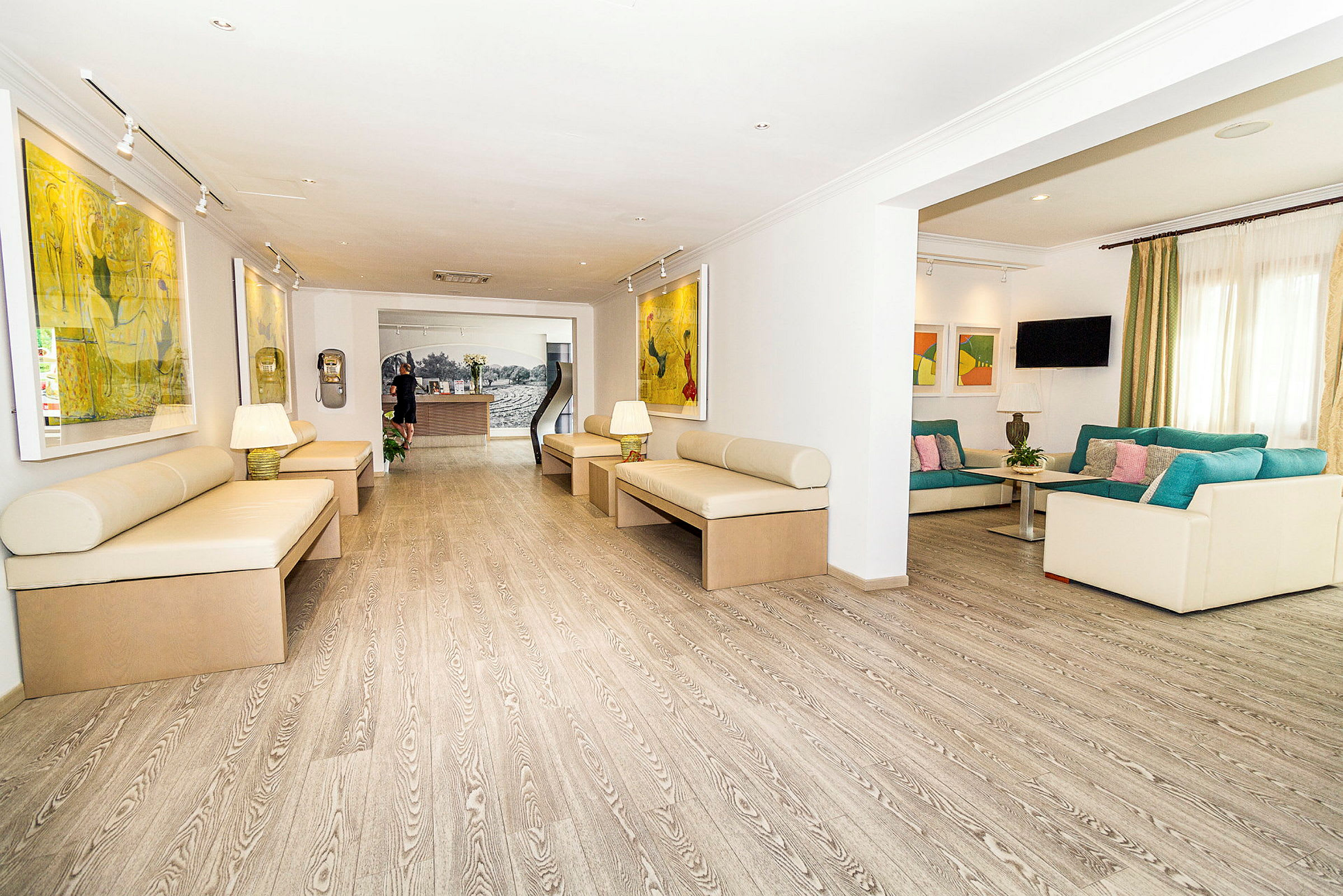 Ett rymligt, ljust hotellobby område med soffor och konst på väggarna. (AI-genererad text)