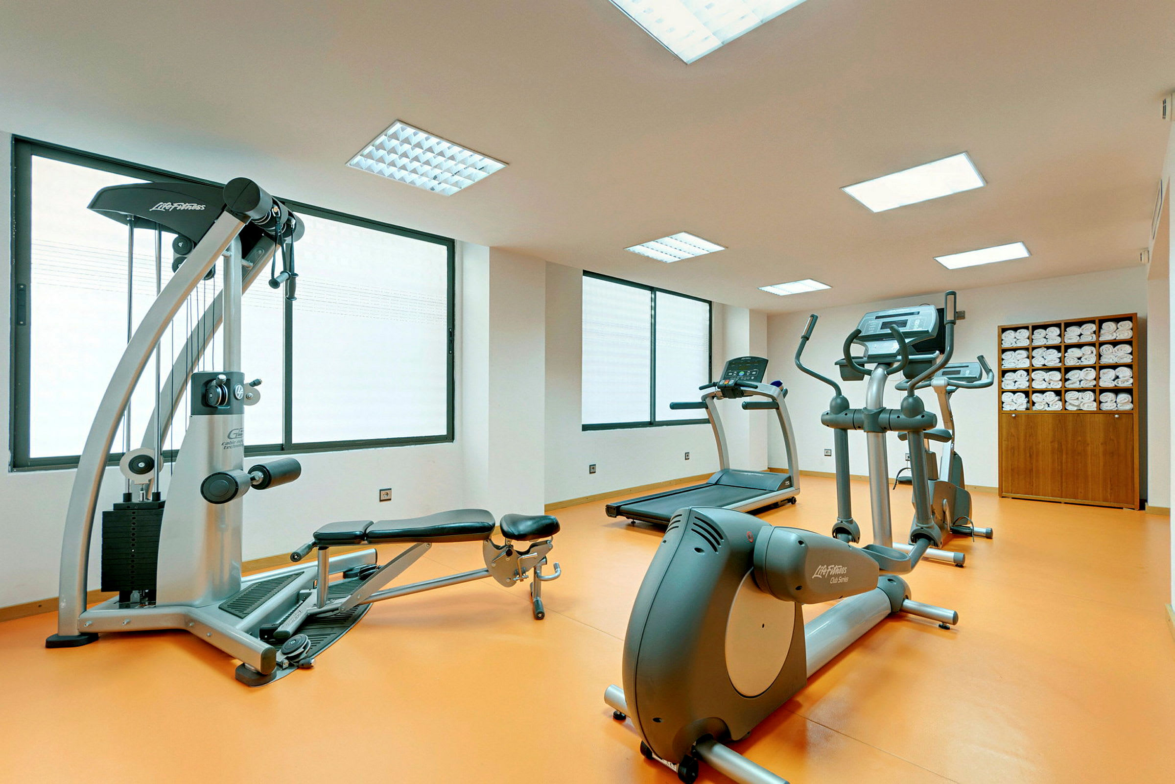 Ett gym med träningsmaskiner och ett skåp med handdukar. (AI-genererad text)