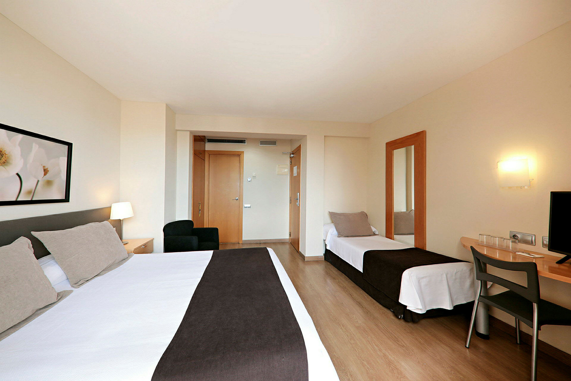 Ett hotellrum med två sängar, ett skrivbord och en spegel. (AI-genererad text)