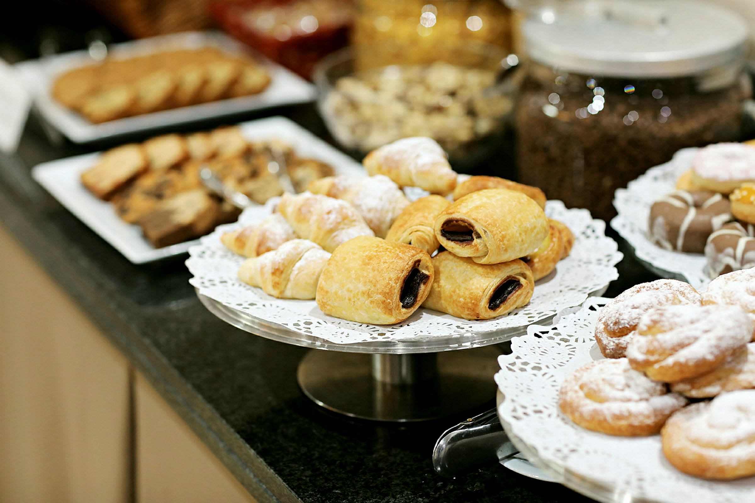 Ett urval av bakverk på tallrikar, inklusive croissanter och andra söta bakverk. (AI-genererad text)