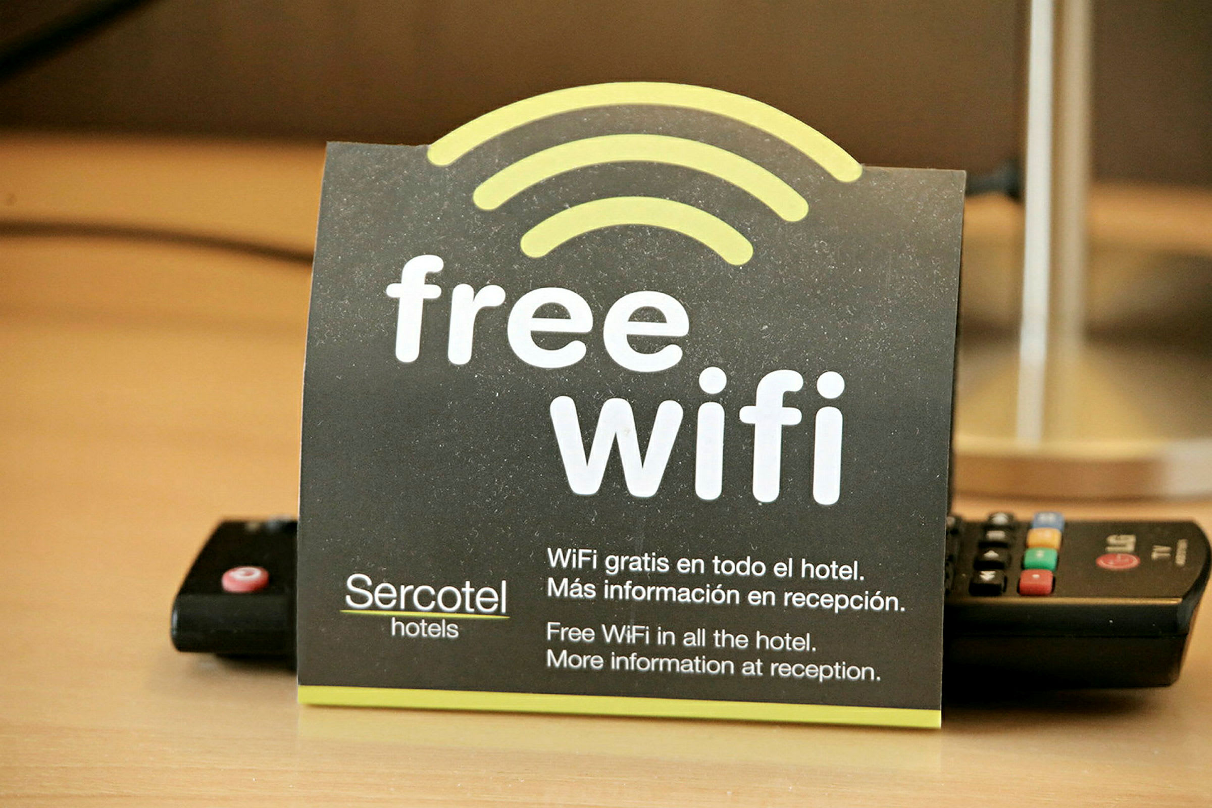 Ett kort som informerar om gratis Wi-Fi på ett hotell, med text på både engelska och spanska. (AI-genererad text)