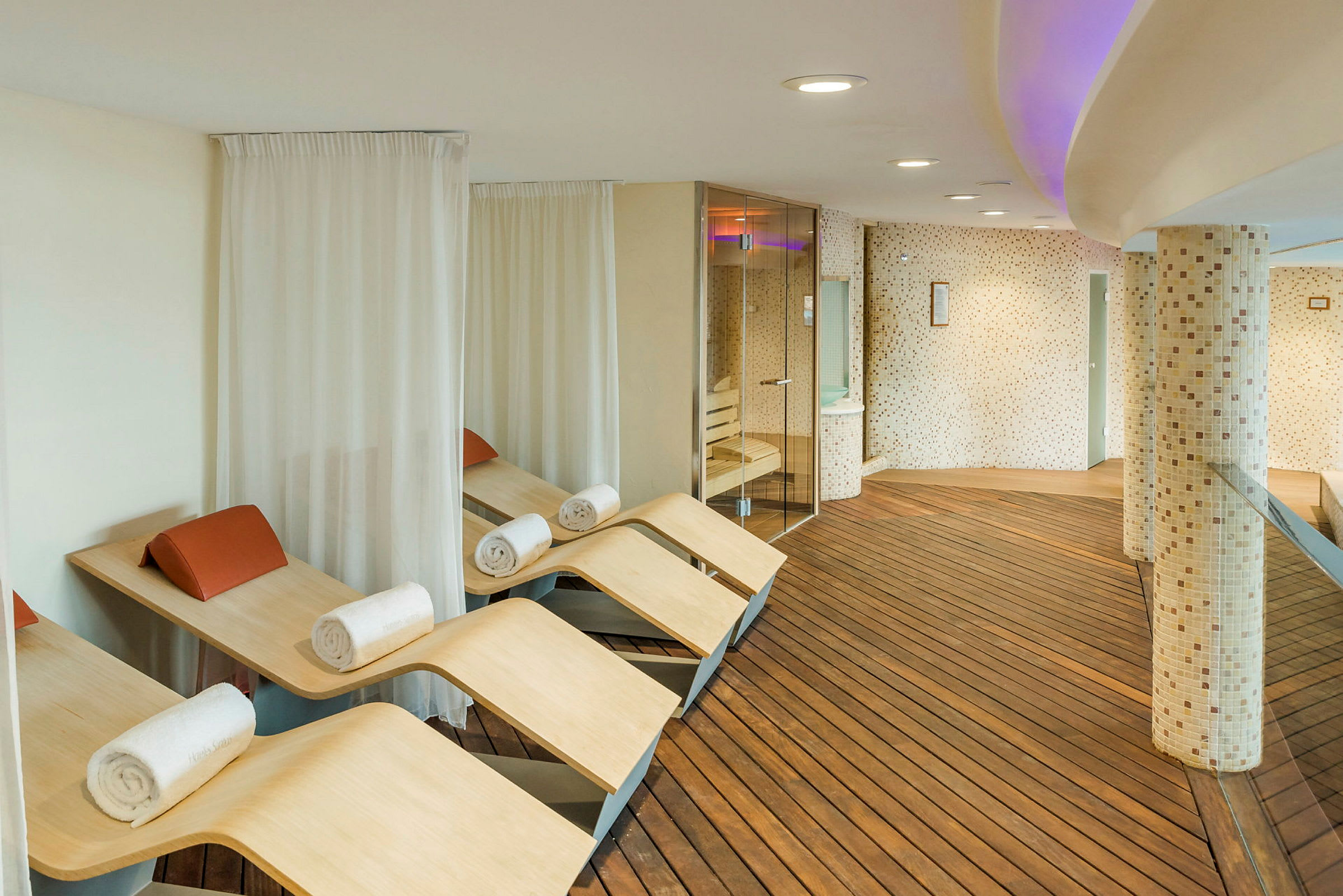 Modern spa-avkopplingsarea med träbänkar och handdukar. (AI-genererad text)
