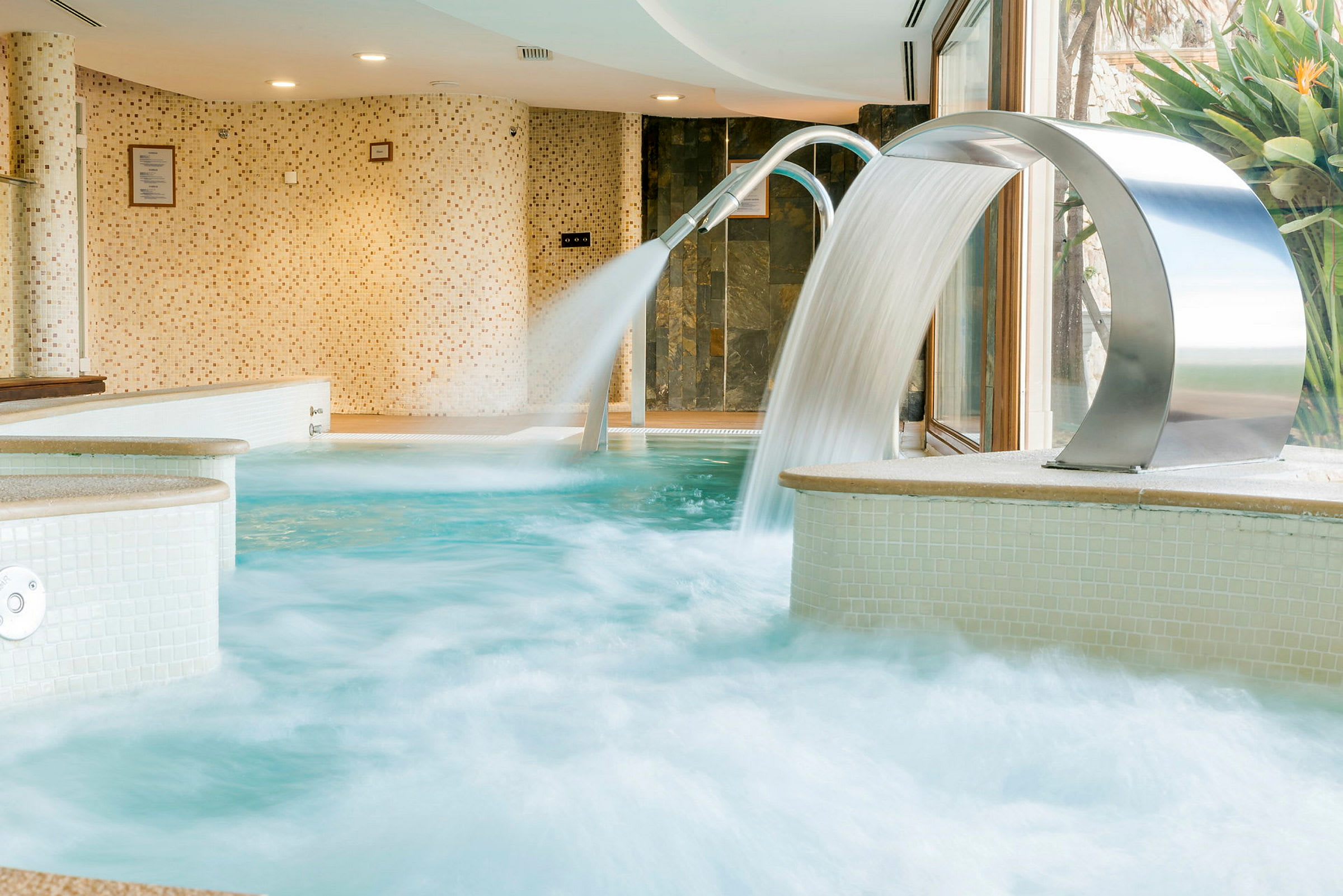 Inomhuspool med vattenfall och jacuzzifunktioner. (AI-genererad text)