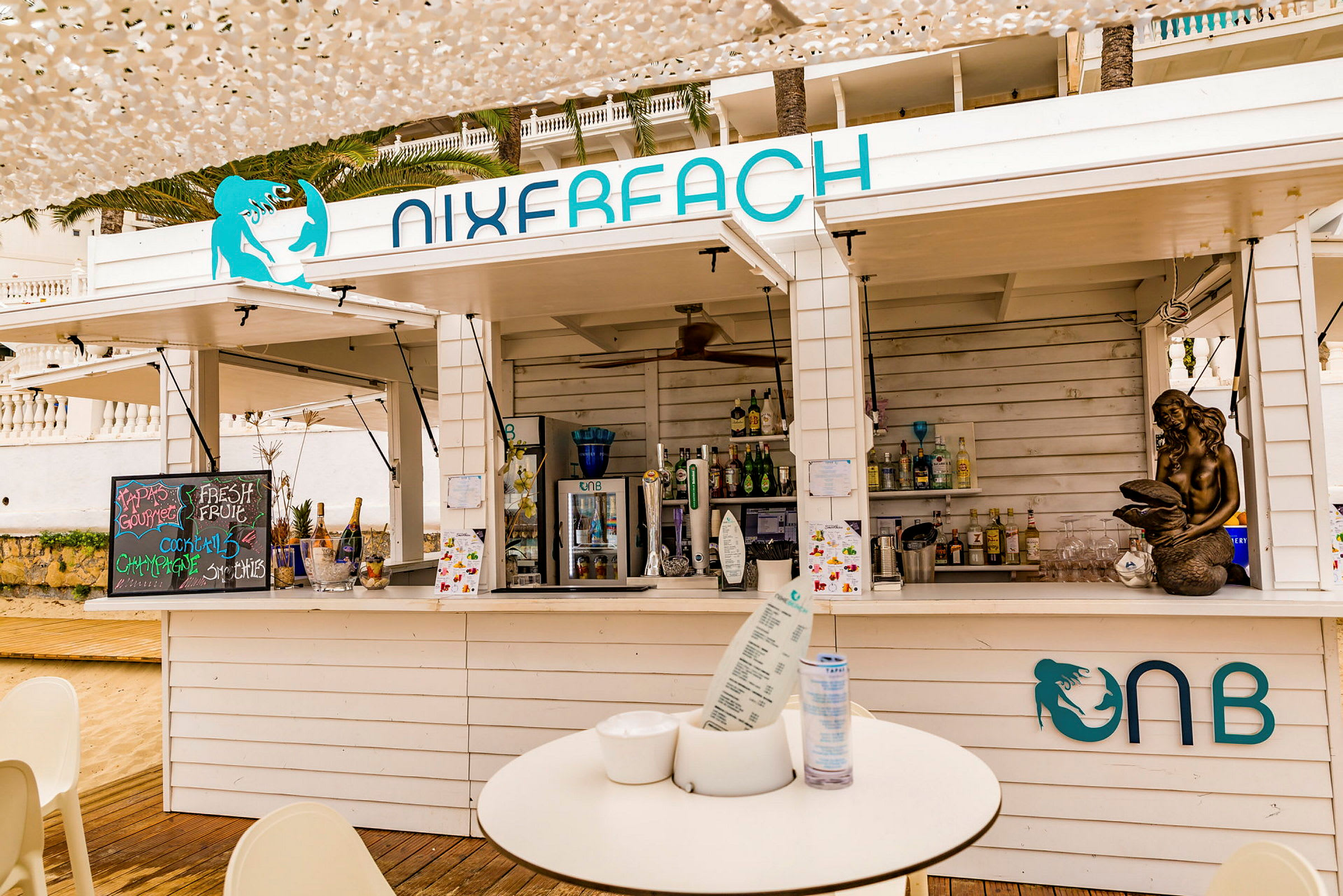 En strandbar med olika drycker och dekorationer. (AI-genererad text)