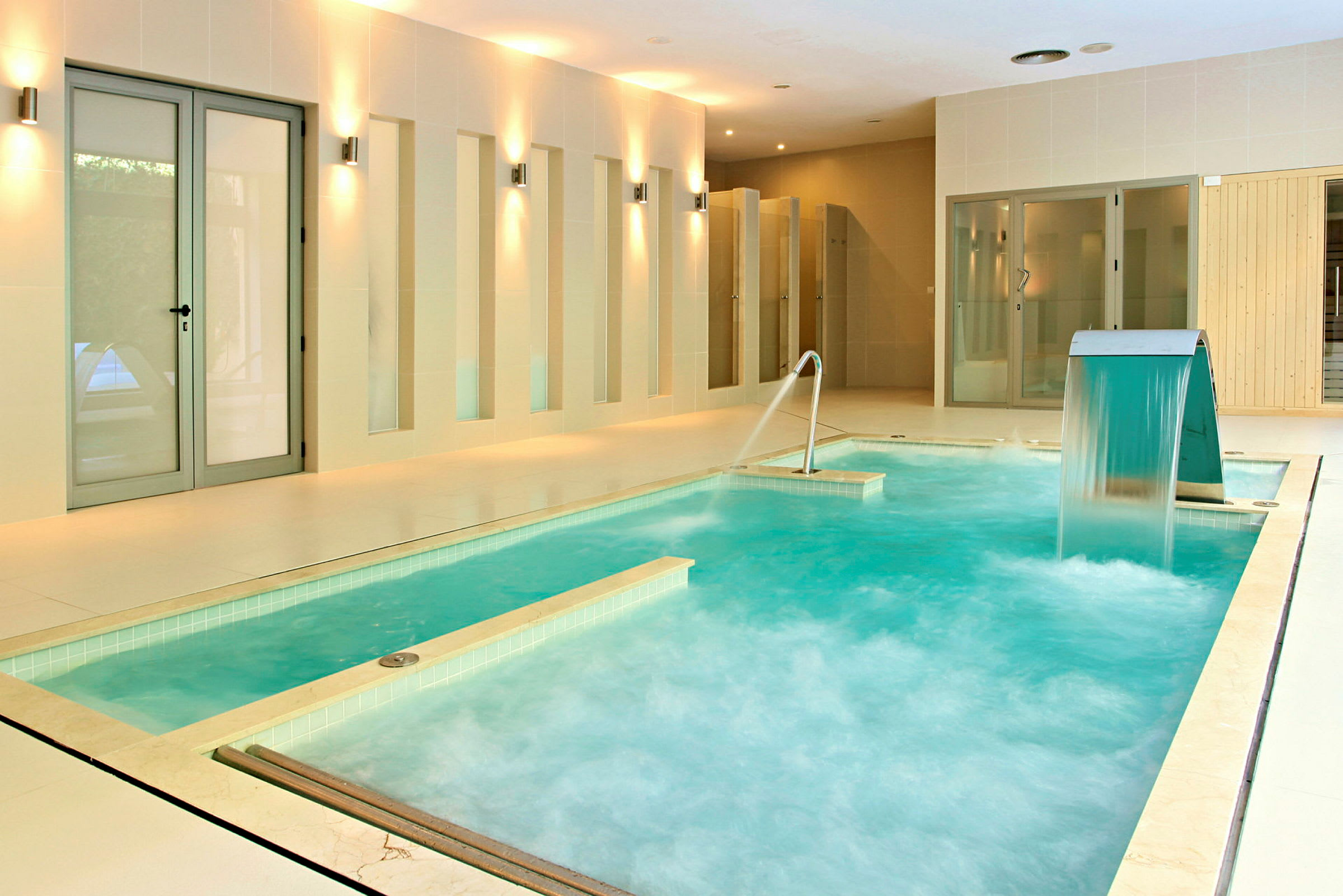 Inomhuspool med vattenfall och jacuzzi-strålar. (AI-genererad text)
