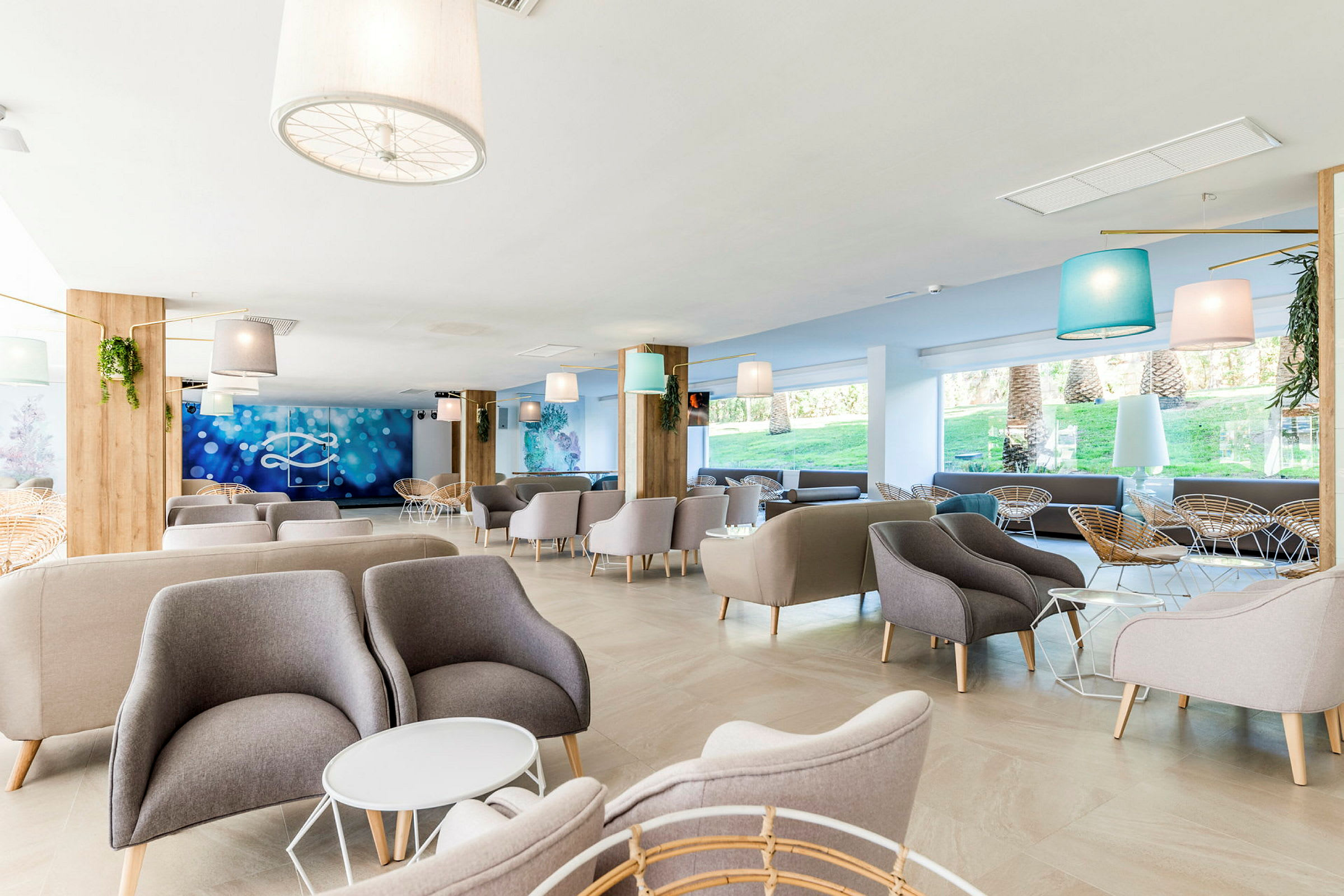 Bild på en ljus och modern hotellobby med bekväma fåtöljer och soffor, samt stora fönster som släpper in dagsljus. (AI-genererad text)
