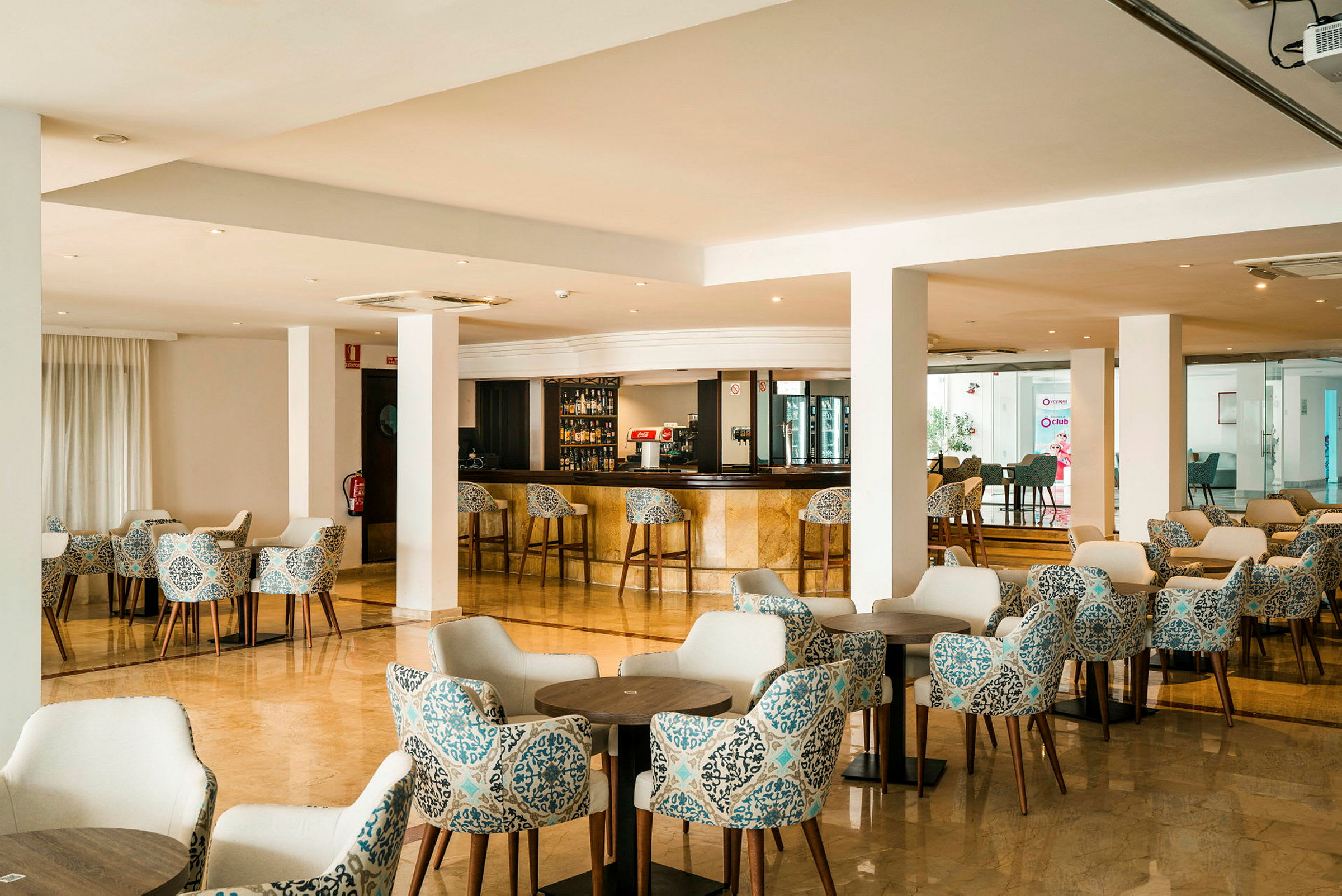 En hotellbar med sittgrupper och bord. (AI-genererad text)