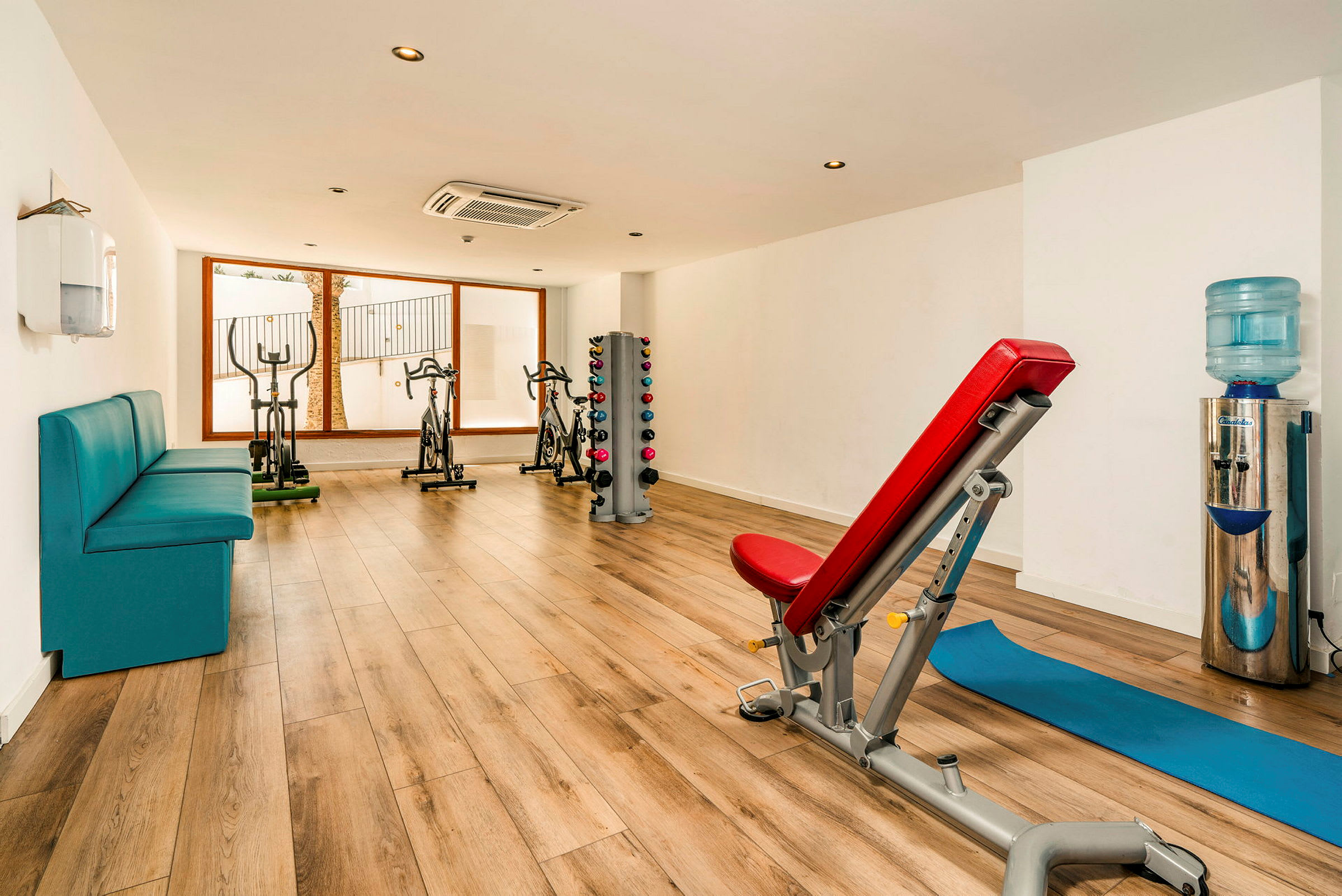 Ett gym med träningsutrustning, en bänk och hantlar. (AI-genererad text)