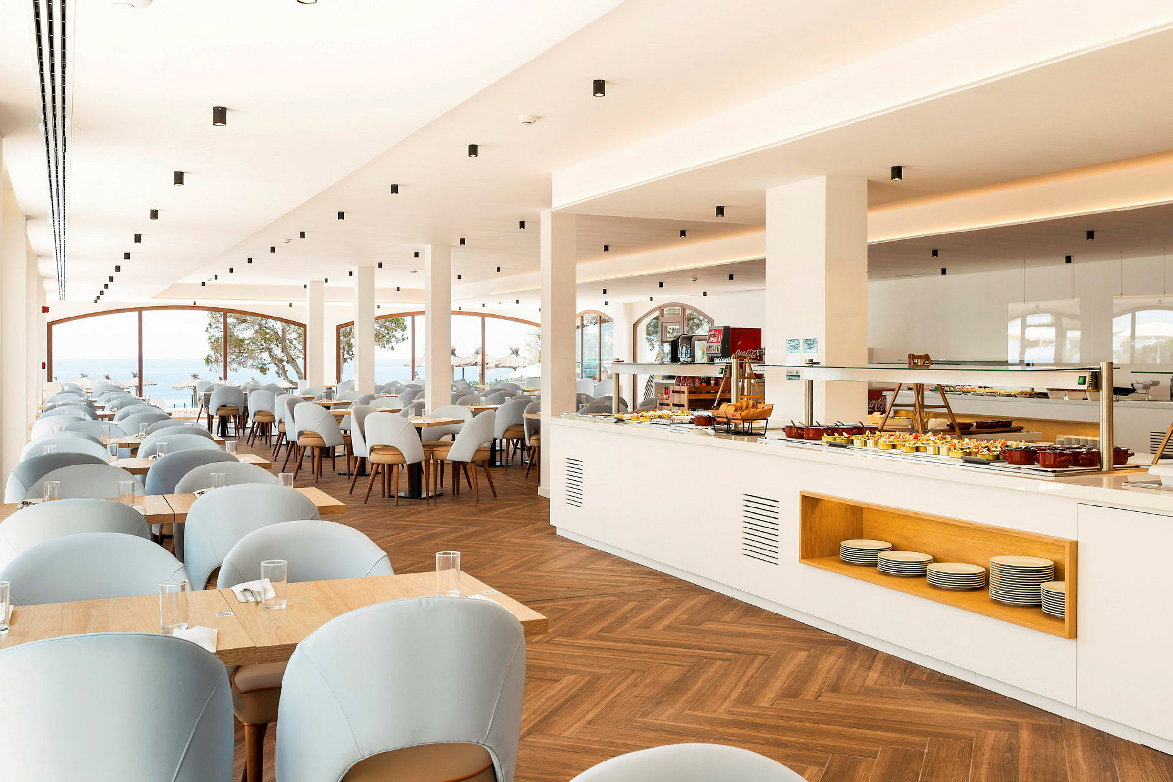 En ljus restaurang med bord och stolar samt en buffé. (AI-genererad text)