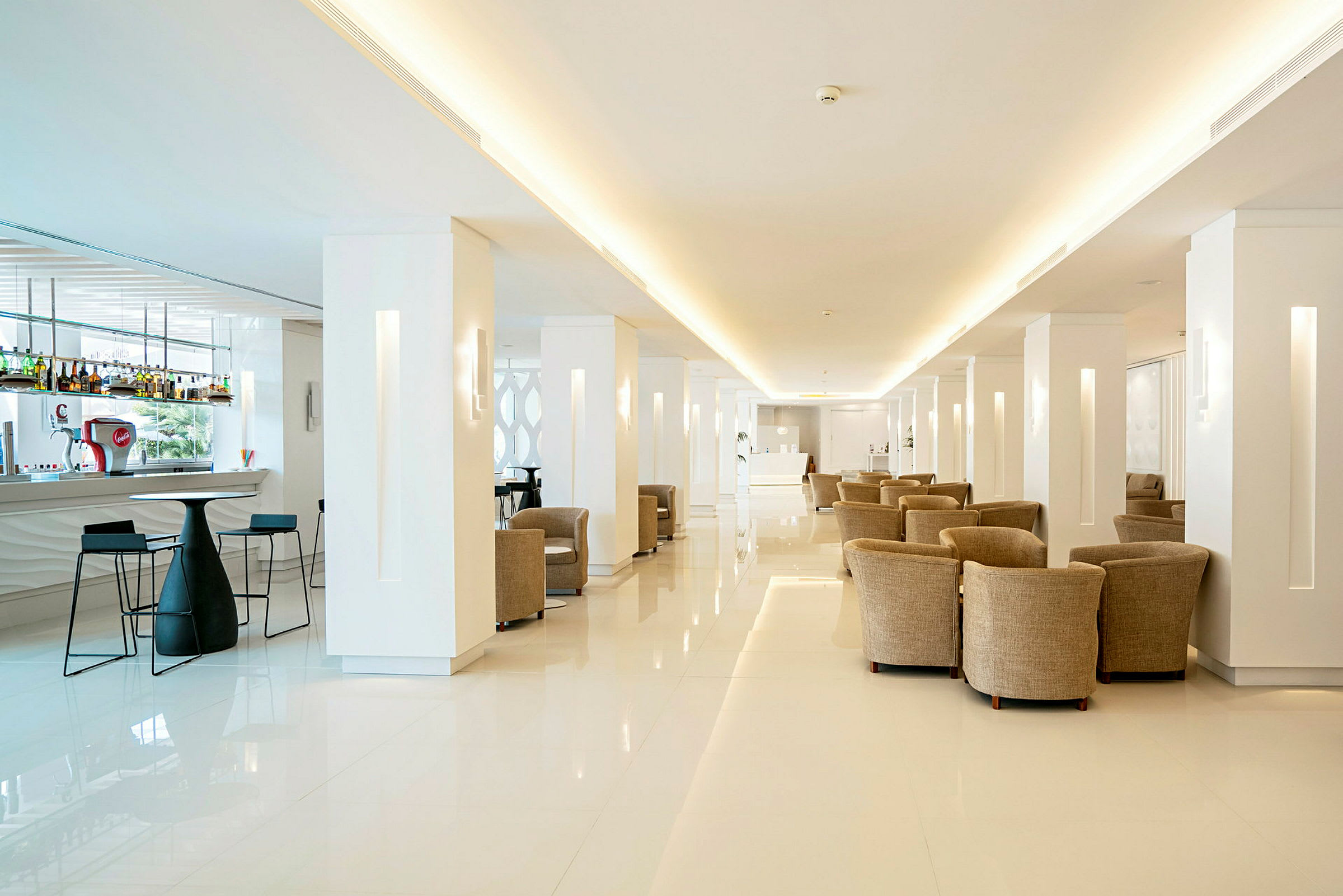 Ljus och modern hotellobby med bar och sittgrupper. (AI-genererad text)