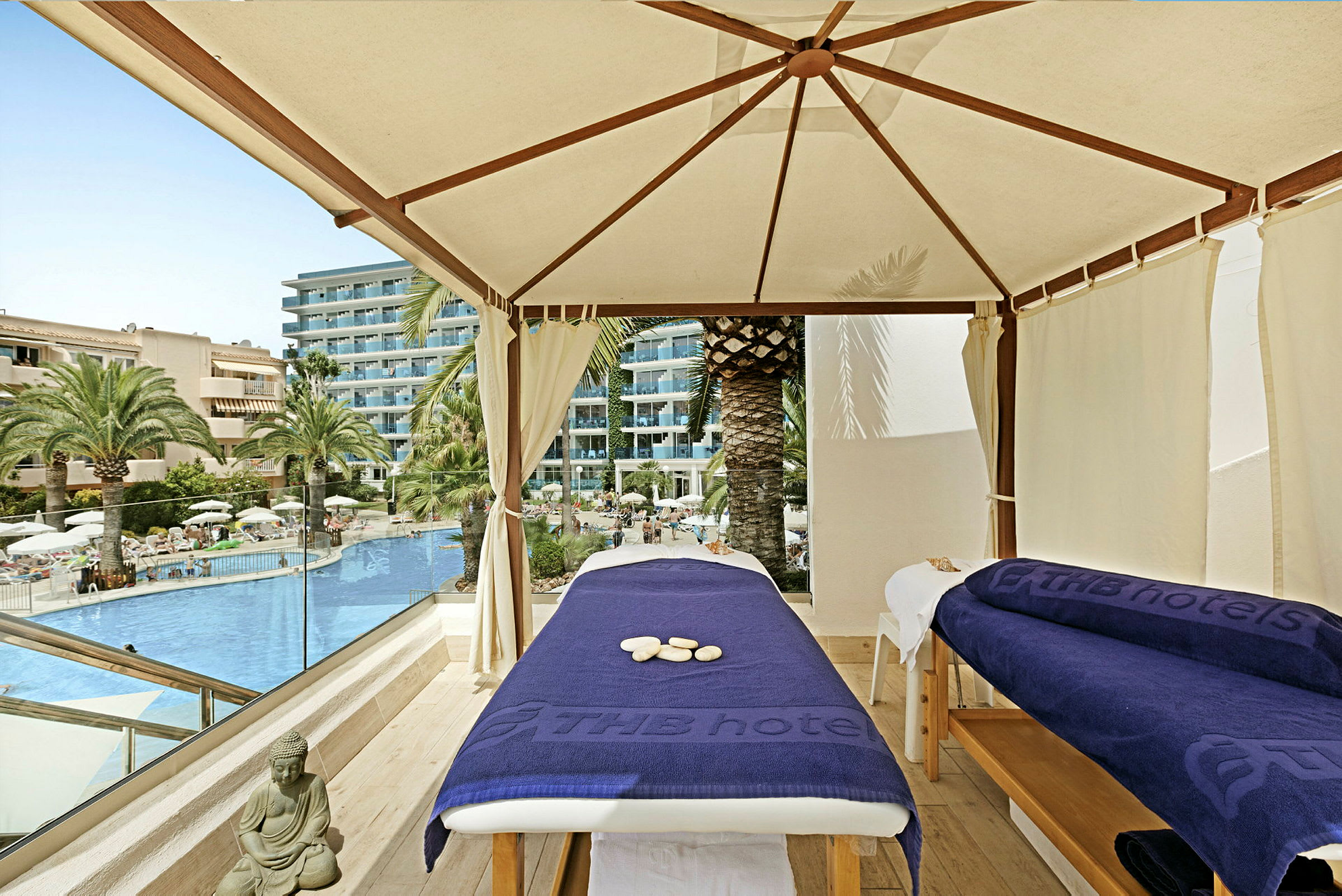 Två massagebänkar under en tältliknande struktur vid en hotellpool. (AI-genererad text)