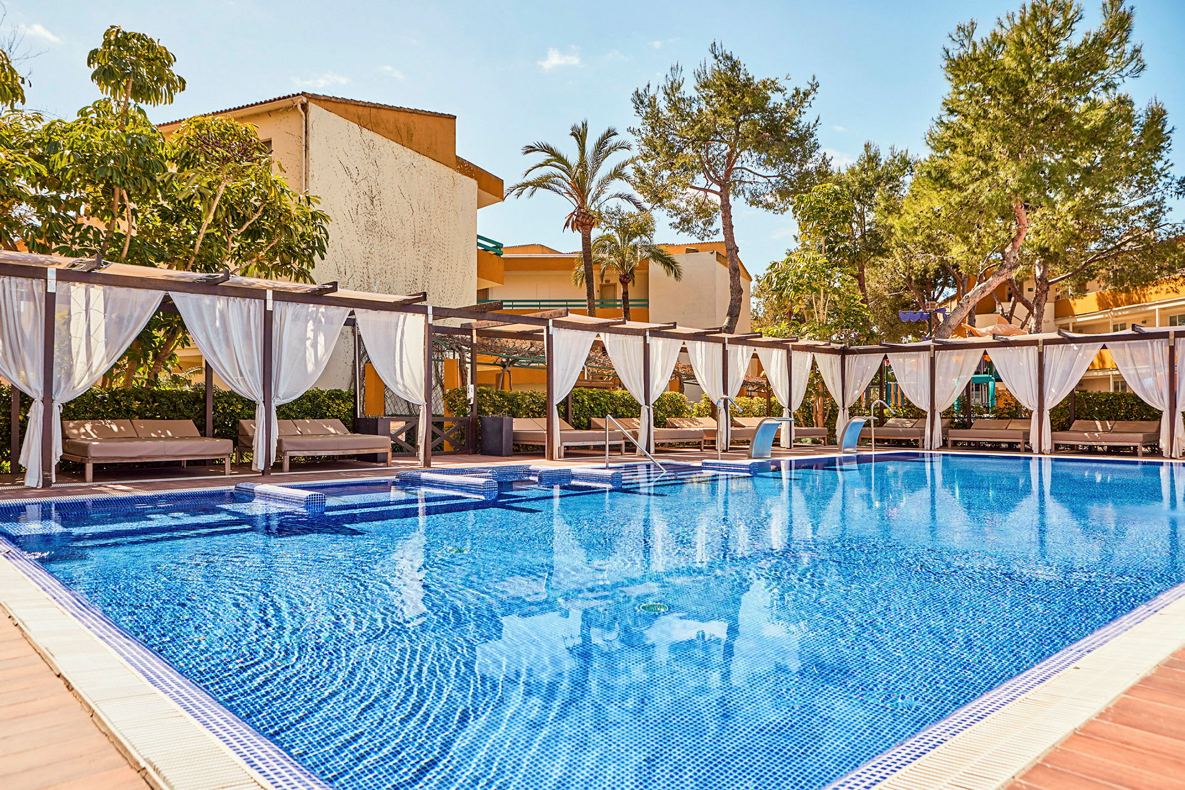 Pool med solbäddar under vita draperingar. (AI-genererad text)